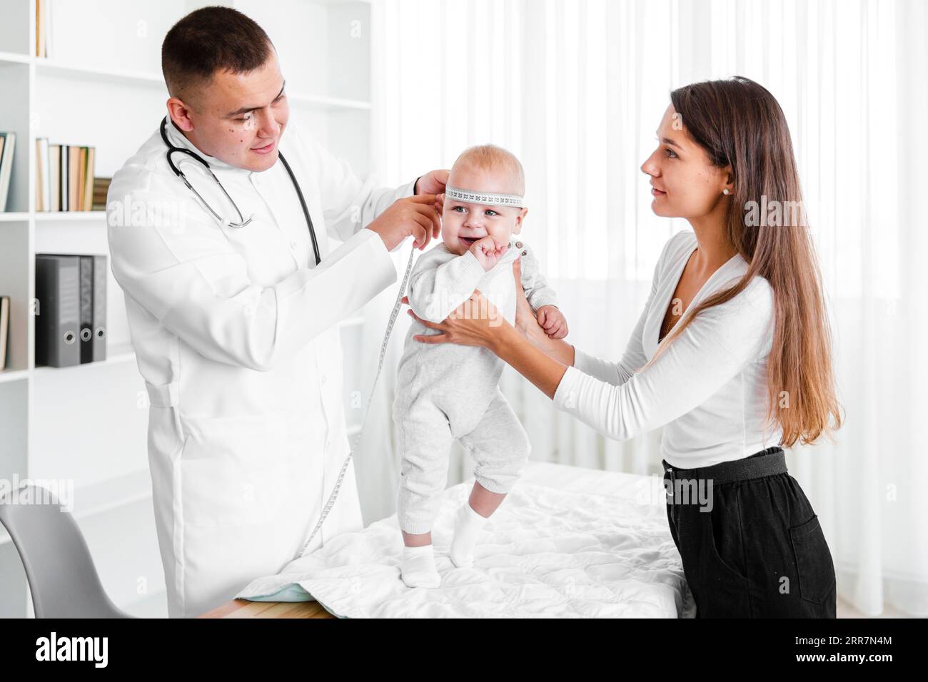 Mother holding baby while doctor looking it Stock Photo - Alamy