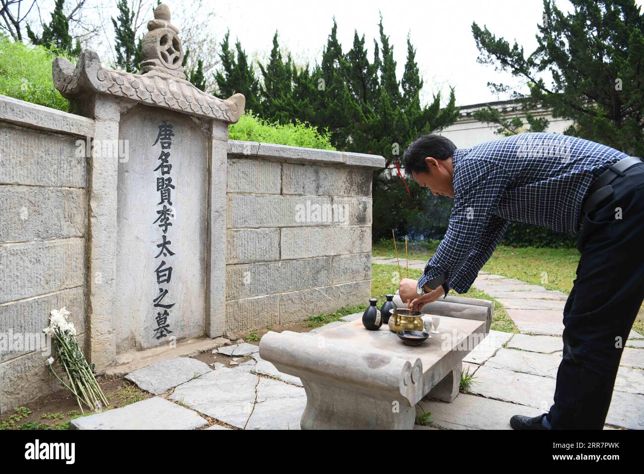 210402 -- DANGTU, April 2, 2021 -- Gu Changxin pays respect to Li Bai in front of his tomb at Li Bai cultural park in Dangtu County of Maanshan City, east China s Anhui Province, March 31, 2021. The tomb of Li Bai, a famous poet of Tang Dynasty 618-907, is located at the foot of Qingshan Mountain in Dangtu County of Maanshan City. After Li Bai died in Dangtu, his good friend Gu Lanxin offered his land as Li Bai s burial place. Since then, the Gu s family has become the guardian of Li Bai s tomb, which continues to this day. In 1985, 18-year-old Gu Changxin became the 49th generation tomb keepe Stock Photo