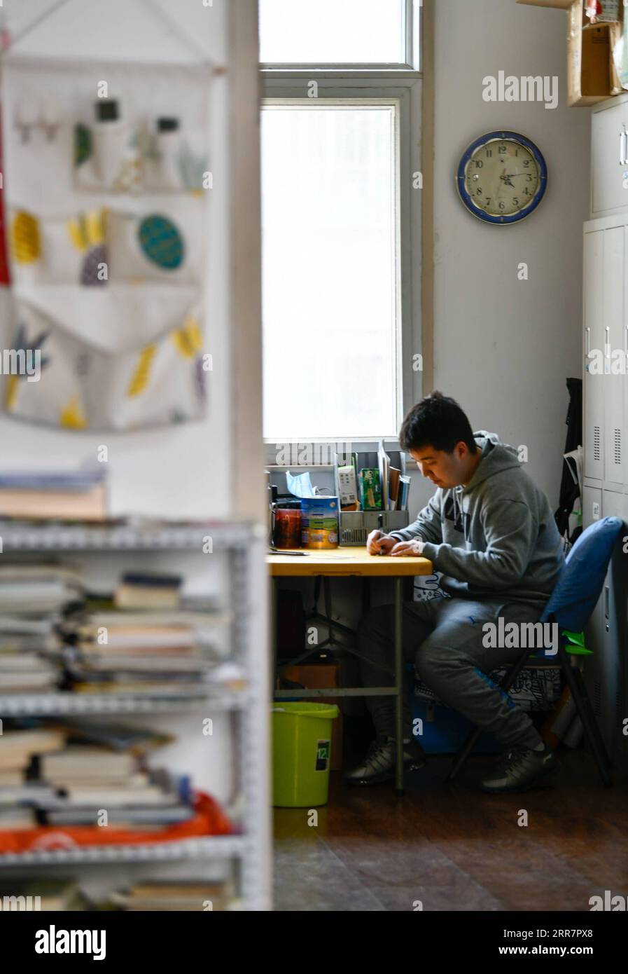 210402 -- TIANJIN, April 2, 2021 -- Zhang Hao practices writing at the autism training center set up by his mother Wu Guixiang in Hedong District, north China s Tianjin, March 30, 2021. In 1998, Zhang Hao was diagnosed with autism at the age of two. Ever since the diagnosis, Zhang s mother Wu Guixiang has spent all her time looking after her son. In order to help Zhang Hao and eight others with autism improve their social engagement after they had become grown-ups, Wu set up an autism training center in 2016, providing them with courses on life, social and vocational skills. Within five years, Stock Photo