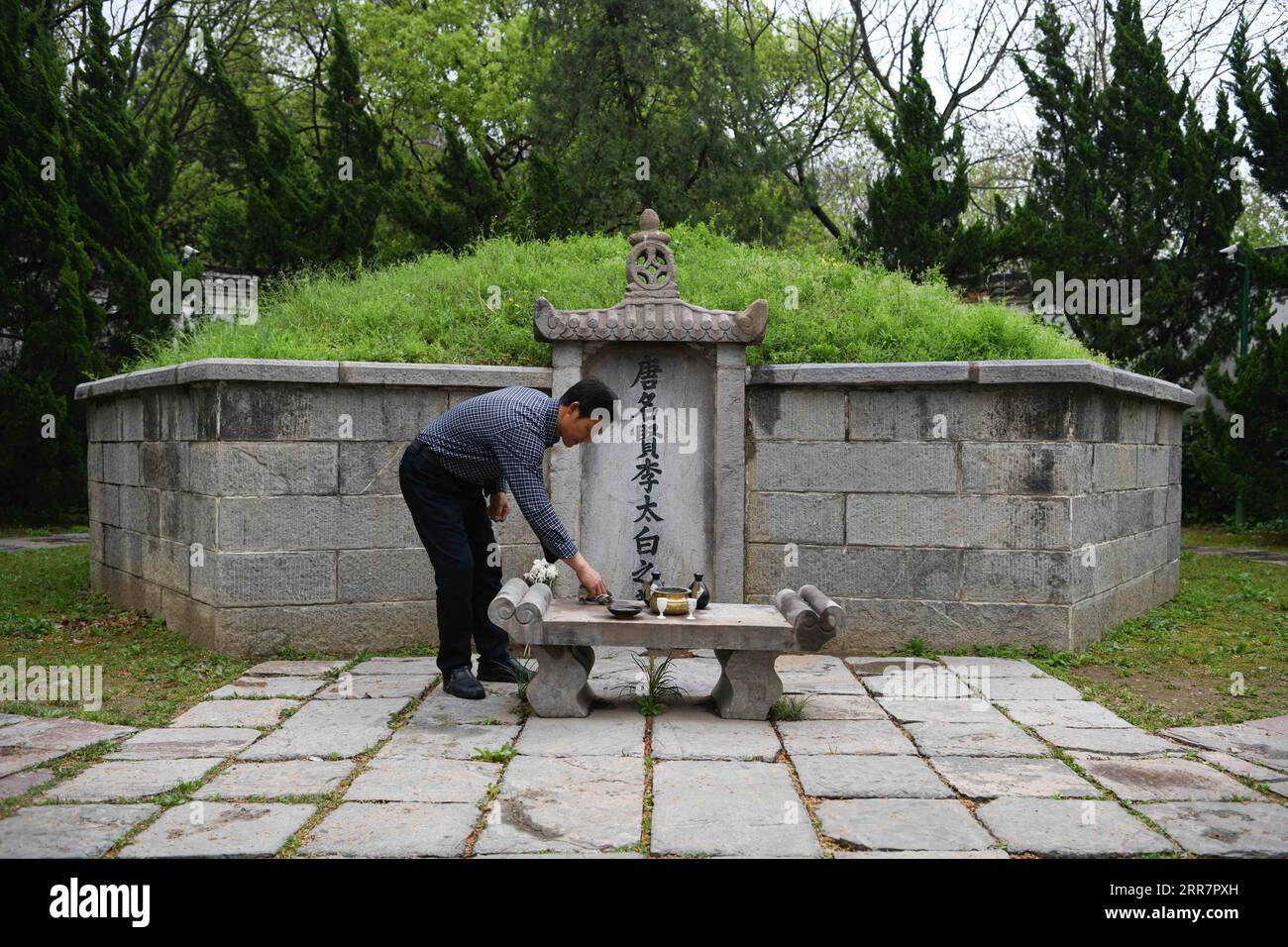 210402 -- DANGTU, April 2, 2021 -- Gu Changxin cleans the altar of Li Bai s tomb at Li Bai cultural park in Dangtu County of Maanshan City, east China s Anhui Province, March 31, 2021. The tomb of Li Bai, a famous poet of Tang Dynasty 618-907, is located at the foot of Qingshan Mountain in Dangtu County of Maanshan City. After Li Bai died in Dangtu, his good friend Gu Lanxin offered his land as Li Bai s burial place. Since then, the Gu s family has become the guardian of Li Bai s tomb, which continues to this day. In 1985, 18-year-old Gu Changxin became the 49th generation tomb keeper. For mor Stock Photo