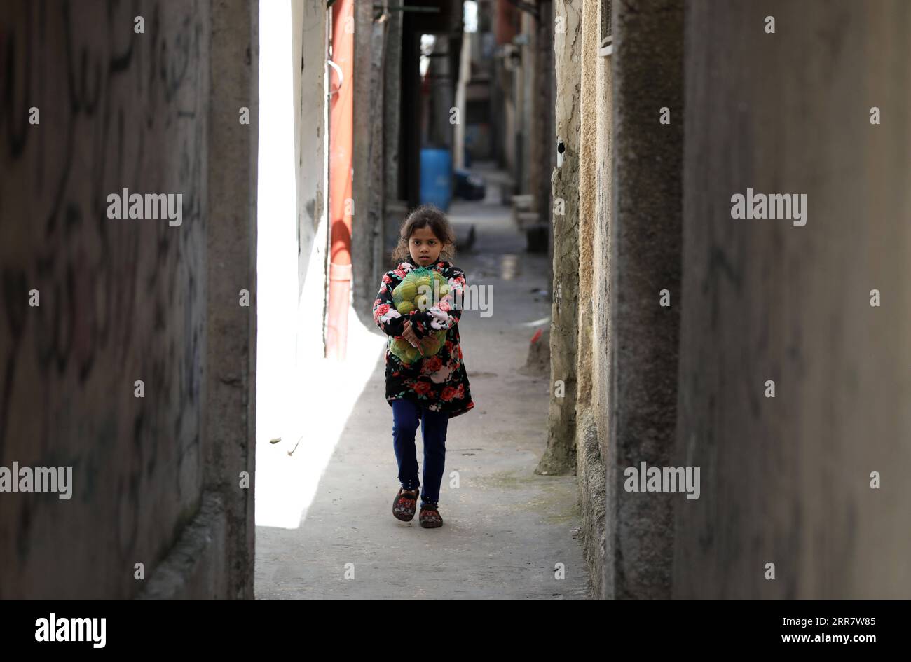 210405 -- NABLUS, April 5, 2021 -- A Palestinian girl carries a bag of lemon in an alley in Balata refugee camp on the Palestinian Children s Day near the West Bank city of Nablus, April 5, 2021. Photo by /Xinhua MIDEAST-NABLUS-PALESTINIAN CHILDREN S DAY AymanxNobani PUBLICATIONxNOTxINxCHN Stock Photo