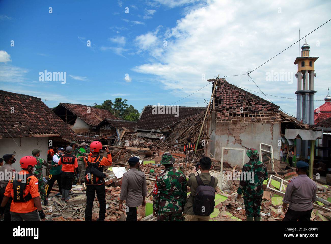 210411 -- EAST JAVA, April 11, 2021 -- Members of search and rescue team are seen near damaged houses after a 6.1 magnitude quake hit Majang Tengah village in Malang, East Java, Indonesia, April 11, 2021. Six people were killed, another one was seriously injured, and scores of buildings were damaged after a 6.1-magnitude quake rocked Indonesia s western province of East Java on Saturday, officials said. The earthquake struck at 2 p.m. Jakarta time 0700 GMT with the epicenter 96 km south of Kepanjen town of Malang district with a depth of 80 km, Andry Sembiring, an official at the Meteorology, Stock Photo