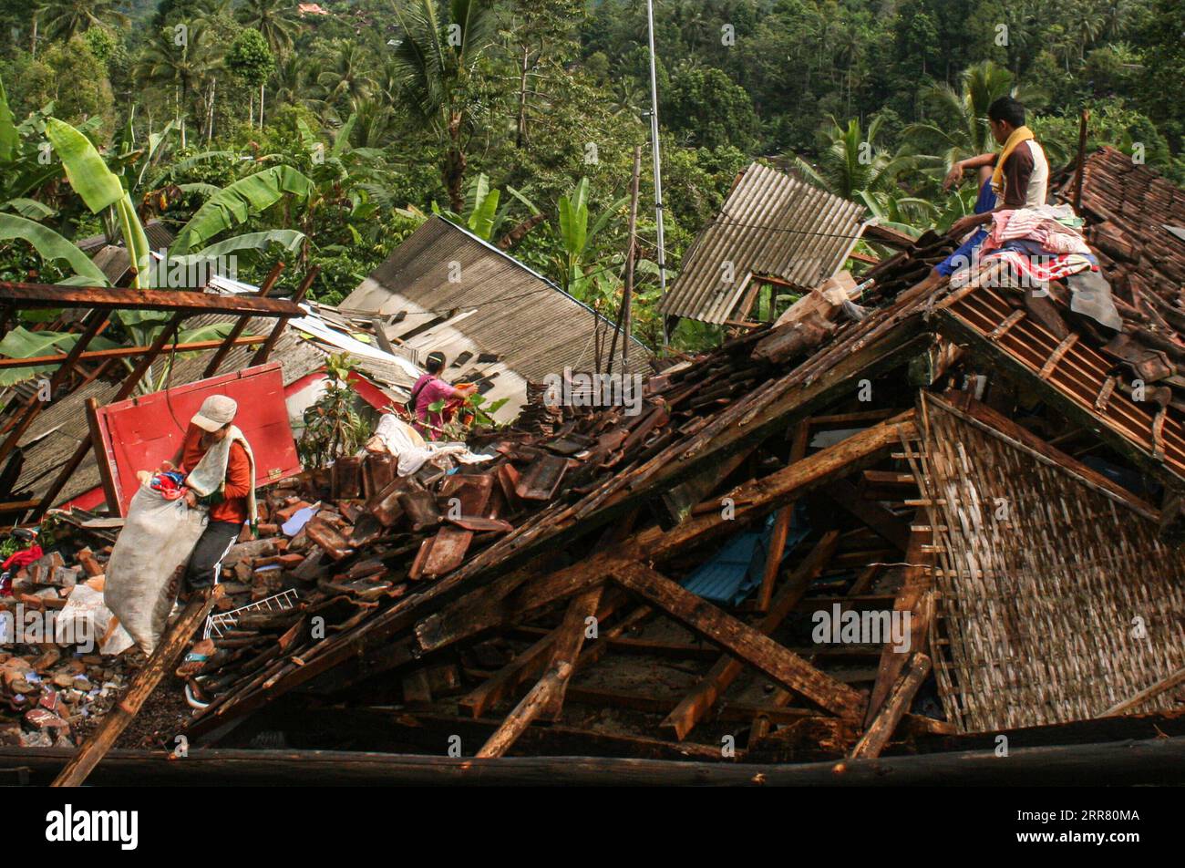 210411 -- EAST JAVA, April 11, 2021 -- People collect their belonging near damaged houses after a 6.1 magnitude quake hit Kali Uling village in Lumajang, East Java, Indonesia, April 11, 2021. Six people were killed, another one was seriously injured, and scores of buildings were damaged after a 6.1-magnitude quake rocked Indonesia s western province of East Java on Saturday, officials said. The earthquake struck at 2 p.m. Jakarta time 0700 GMT with the epicenter 96 km south of Kepanjen town of Malang district with a depth of 80 km, Andry Sembiring, an official at the Meteorology, Climatology a Stock Photo