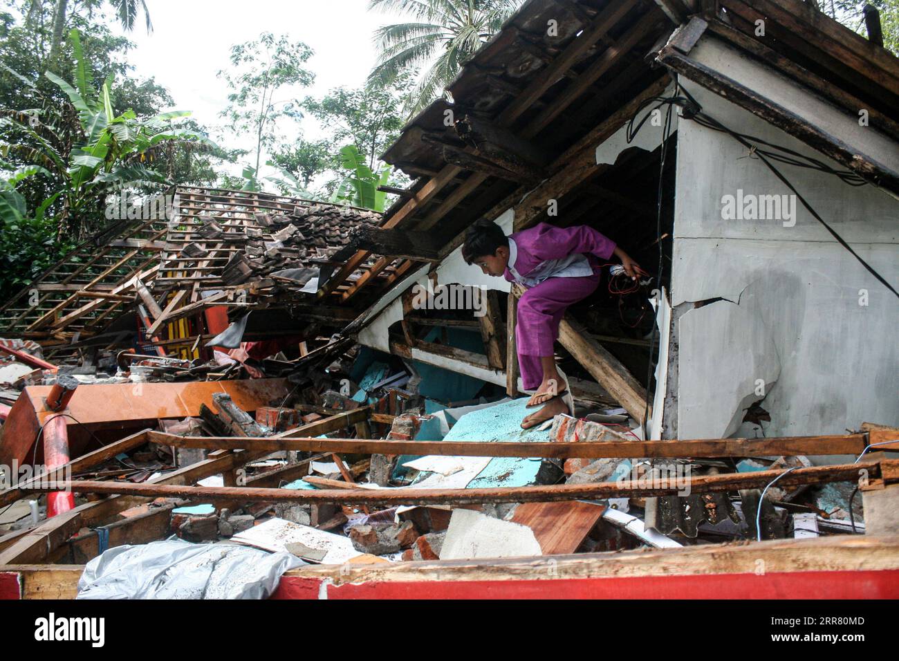 210411 -- EAST JAVA, April 11, 2021 -- A boy exits a damaged house after a 6.1 magnitude quake hit Kali Uling village in Lumajang, East Java, Indonesia, April 11, 2021. Six people were killed, another one was seriously injured, and scores of buildings were damaged after a 6.1-magnitude quake rocked Indonesia s western province of East Java on Saturday, officials said. The earthquake struck at 2 p.m. Jakarta time 0700 GMT with the epicenter 96 km south of Kepanjen town of Malang district with a depth of 80 km, Andry Sembiring, an official at the Meteorology, Climatology and Geophysics Agency, s Stock Photo