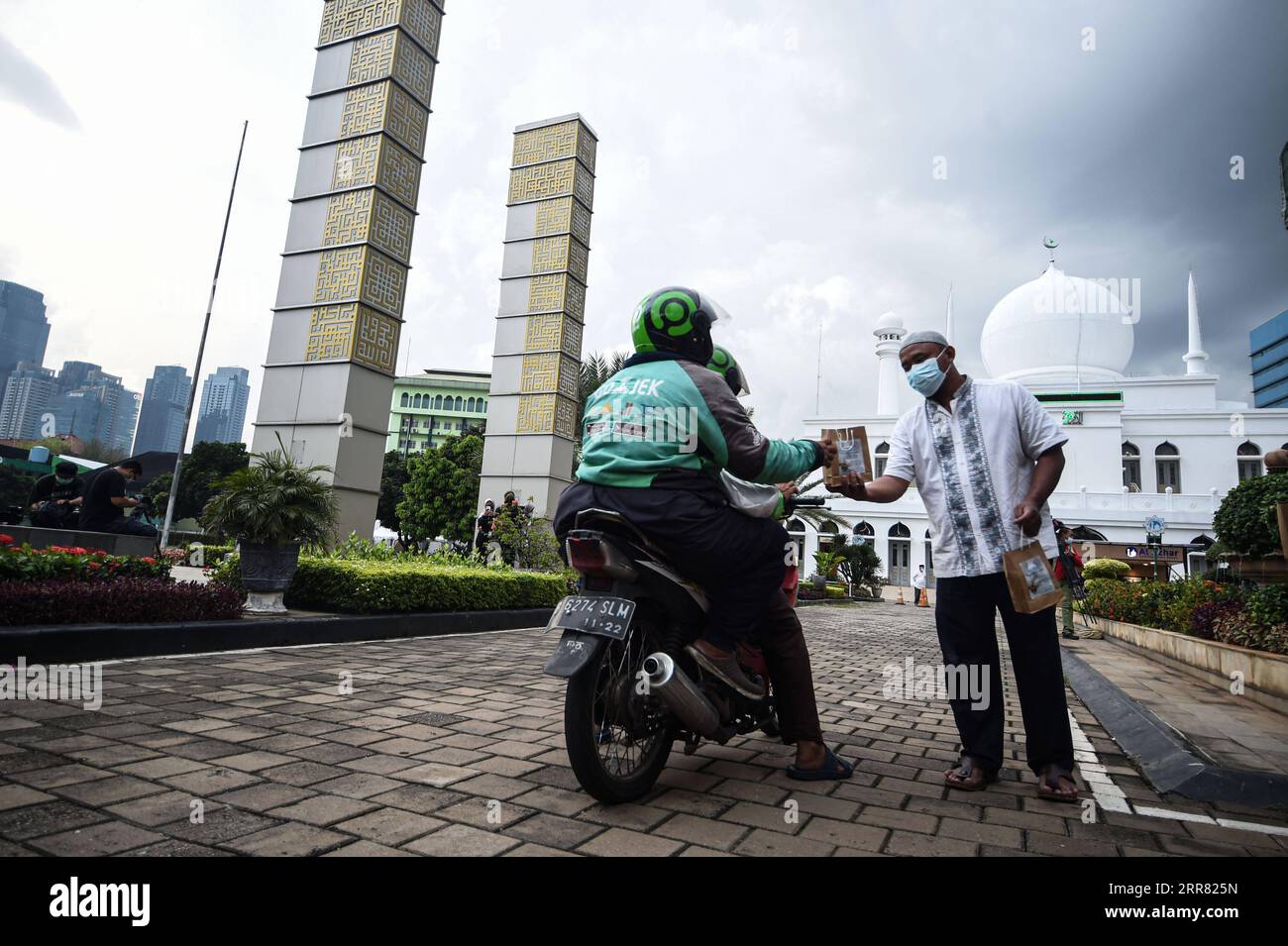 210413 -- JAKARTA, April 13, 2021 -- People receive Iftar, the fast breaking meal at sunset, for free by drive-thru during the holy month of Ramadan at Al-Azhar Mosque in Jakarta, Indonesia, April 13, 2021.  INDONESIA-JAKARTA-RAMADAN-IFTAR AgungxKuncahyaxB. PUBLICATIONxNOTxINxCHN Stock Photo