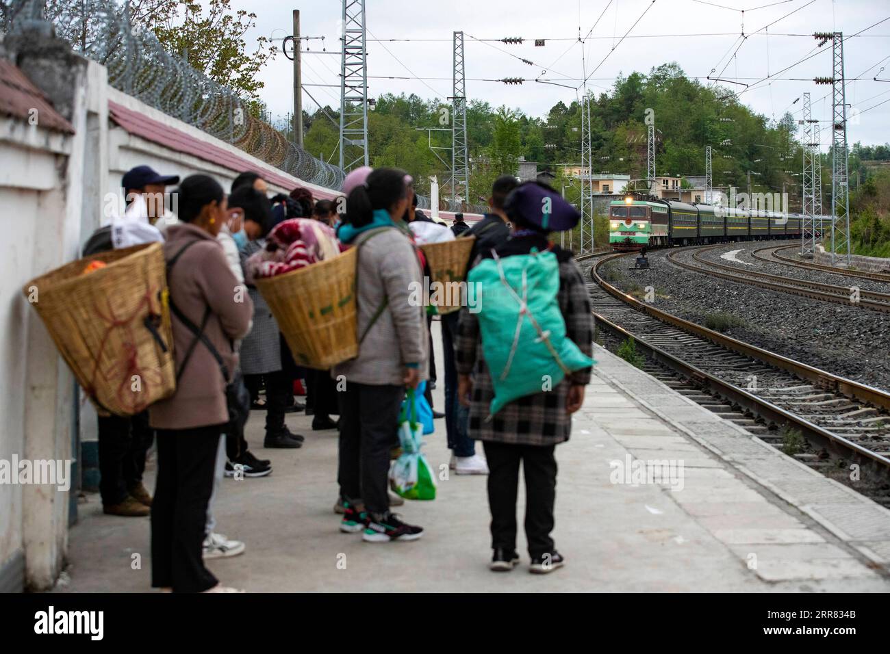 210415 -- XICHANG, April 15, 2021 -- Passengers wait for boarding the 5633 train at Puxiong Station in southwest China s Sichuan Province, April 11, 2021. As modern high-speed trains shoot past new stations throughout China, a pair of slow-speed trains still run through Daliang Mountains. The 5633/5634 trains run between Puxiong and Panzhihua of Sichuan Province with an average speed less than 40 km per hour. The journey with 26 stations in between takes eleven hours and four minutes, with the ticket prices ranging from 2 yuan to 25.5 yuanabout 0.3-3.9 U.S. dollars. The slow-speed trains send Stock Photo