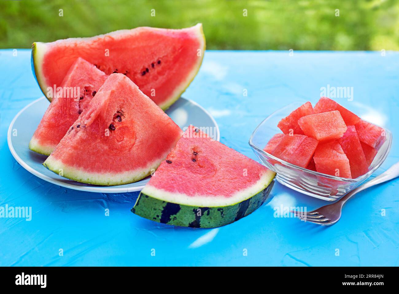 Fresh Sliced Watermelon In Blue Table Background Outdoors At Home fresh-sliced-watermelon-in-blue-table-background-outdoors-at-home