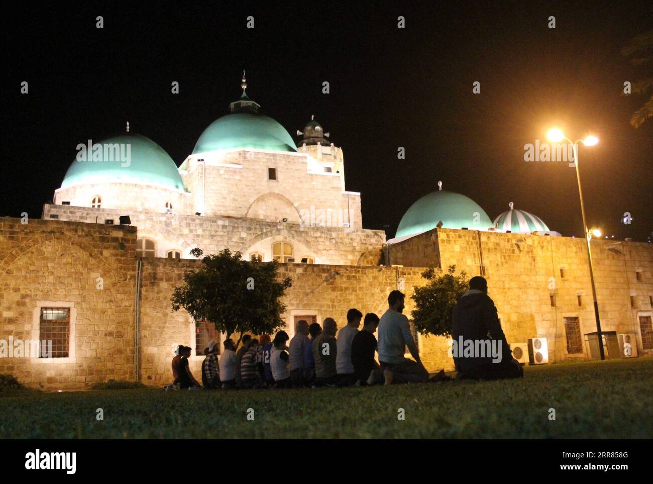 210418 -- TRIPOLI LEBANON, April 18, 2021 -- People perform evening prayers during the Islamic holy month of Ramadan outside a mosque in Tripoli, Lebanon, on April 18, 2021. Photo by /Xinhua LEBANON-TRIPOLI-RAMADAN Khaled PUBLICATIONxNOTxINxCHN Stock Photo