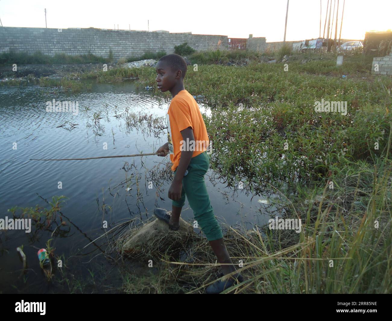 210419 -- LUSAKA, April 19, 2021 -- A boy fishes at a popular dam in Misisi compound, a slum in Zambia s capital Lusaka on April 12, 2021. Photo by /Xinhua TO GO WITH Feature: Slum children in Zambia help supplement household food supplies ZAMBIA-LUSAKA-SLUM CHILDREN-FISHING LillianxBanda PUBLICATIONxNOTxINxCHN Stock Photo