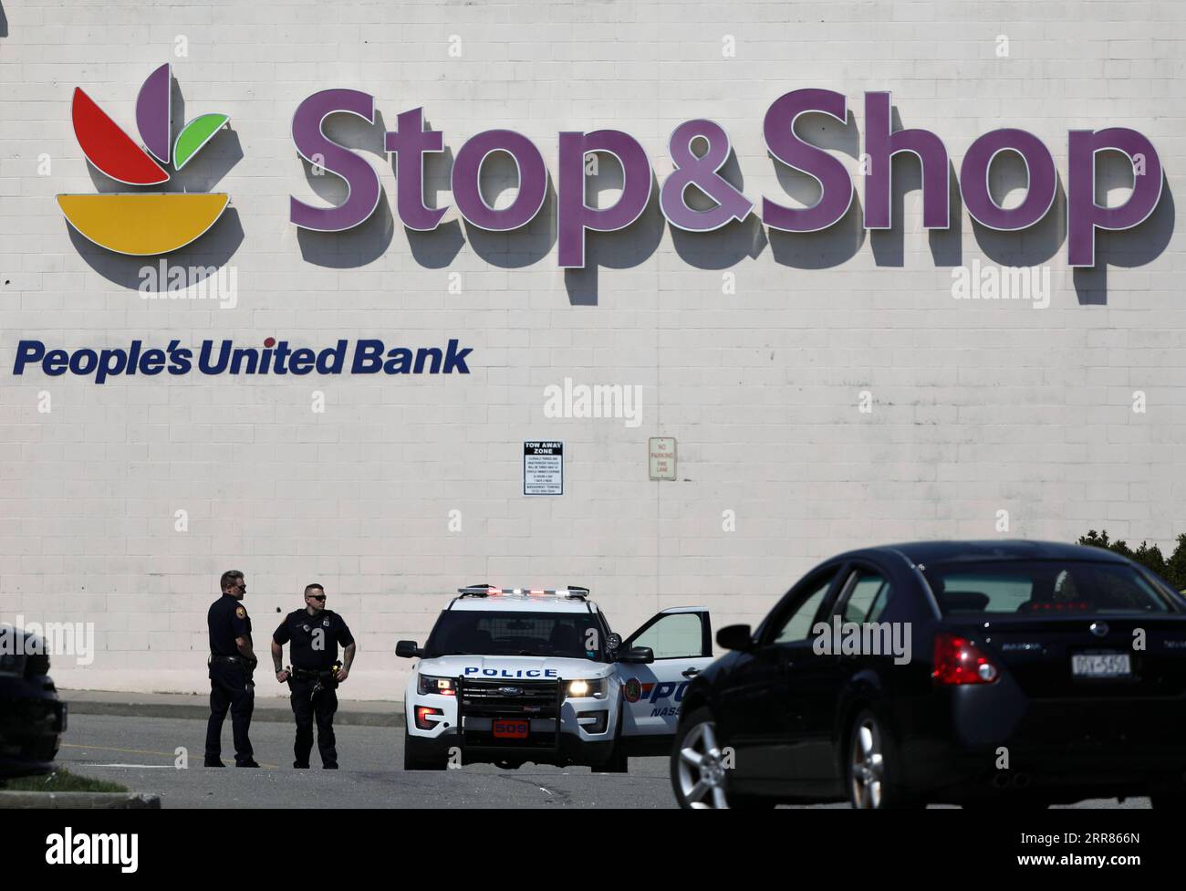 210420 -- NEW YORK, April 20, 2021 -- Policemen stand guard outside a Stop & Shop grocery store where a shooting took place in West Hempstead, New York, the United States, on April 20, 2021. A suspect in a shooting at the suburban New York grocery store on Tuesday was arrested after remaining at large for hours, local police said. The shooting, leaving one dead and two others injured, occurred late morning Tuesday at an office of the Stop & Shop grocery store in West Hempstead, according to police.  U.S.-NEW YORK-WEST HEMPSTEAD-SHOOTING WangxYing PUBLICATIONxNOTxINxCHN Stock Photo