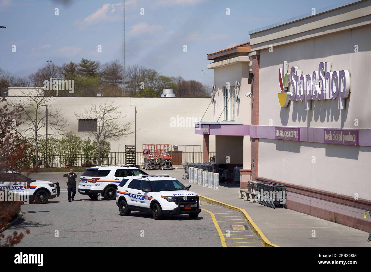210420 -- NEW YORK, April 20, 2021 -- A policeman is seen outside a Stop & Shop grocery store where a shooting took place in West Hempstead, New York, the United States, on April 20, 2021. A suspect in a shooting at the suburban New York grocery store on Tuesday was arrested after remaining at large for hours, local police said. The shooting, leaving one dead and two others injured, occurred late morning Tuesday at an office of the Stop & Shop grocery store in West Hempstead, according to police.  U.S.-NEW YORK-WEST HEMPSTEAD-SHOOTING WangxYing PUBLICATIONxNOTxINxCHN Stock Photo