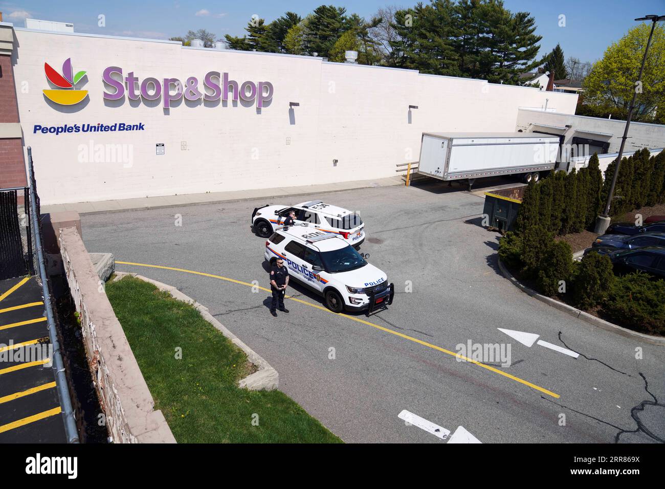 210420 -- NEW YORK, April 20, 2021 -- Policemen stand guard outside a Stop & Shop grocery store where a shooting took place in West Hempstead, New York, the United States, on April 20, 2021. A suspect in a shooting at the suburban New York grocery store on Tuesday was arrested after remaining at large for hours, local police said. The shooting, leaving one dead and two others injured, occurred late morning Tuesday at an office of the Stop & Shop grocery store in West Hempstead, according to police.  U.S.-NEW YORK-WEST HEMPSTEAD-SHOOTING WangxYing PUBLICATIONxNOTxINxCHN Stock Photo