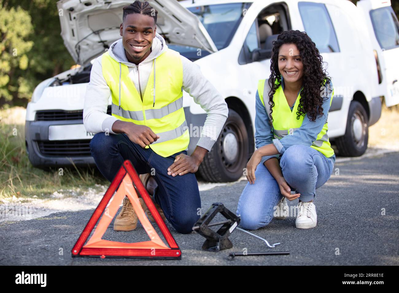 smiling couple and broken down car Stock Photo