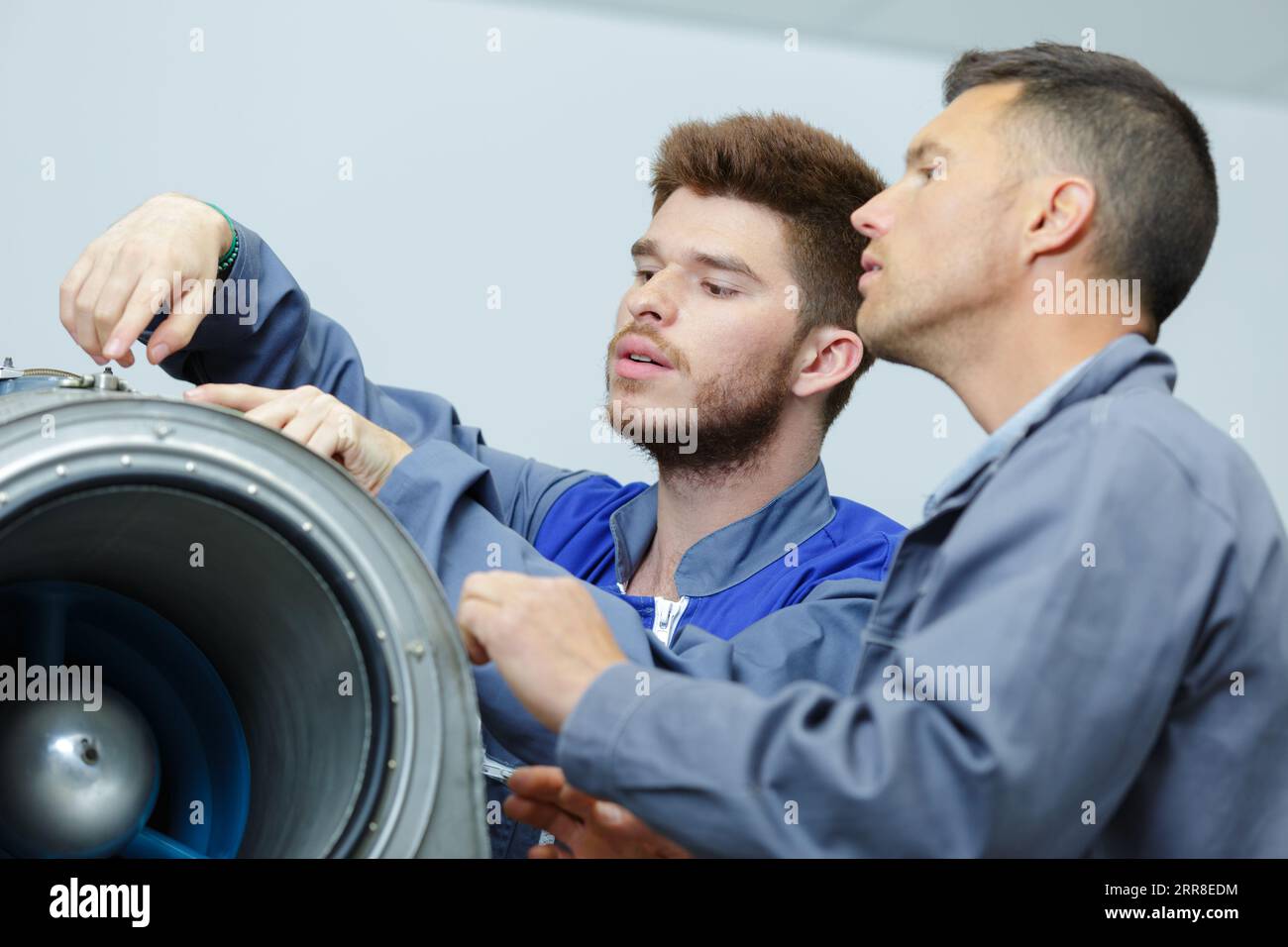 aero engineer and apprentice working on airplane in hangar Stock Photo