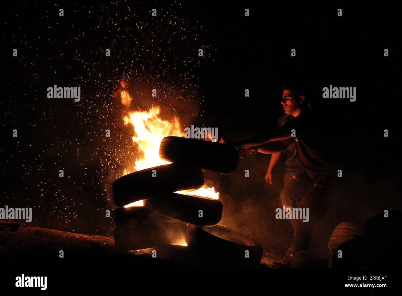 210509 -- GAZA, May 9, 2021 -- A Palestinian protester burns tires during an anti-Israel protest against the violence in Jerusalem, on the Gaza-Israel border east of Gaza City, on May 9, 2021. About 290 Palestinians were injured over the weekend in clashes with Israel s police at the Al-Aqsa Mosque compound and other parts of East Jerusalem. Photo by /Xinhua MIDEAST-GAZA CITY-PROTEST RizekxAbdeljawad PUBLICATIONxNOTxINxCHN Stock Photo