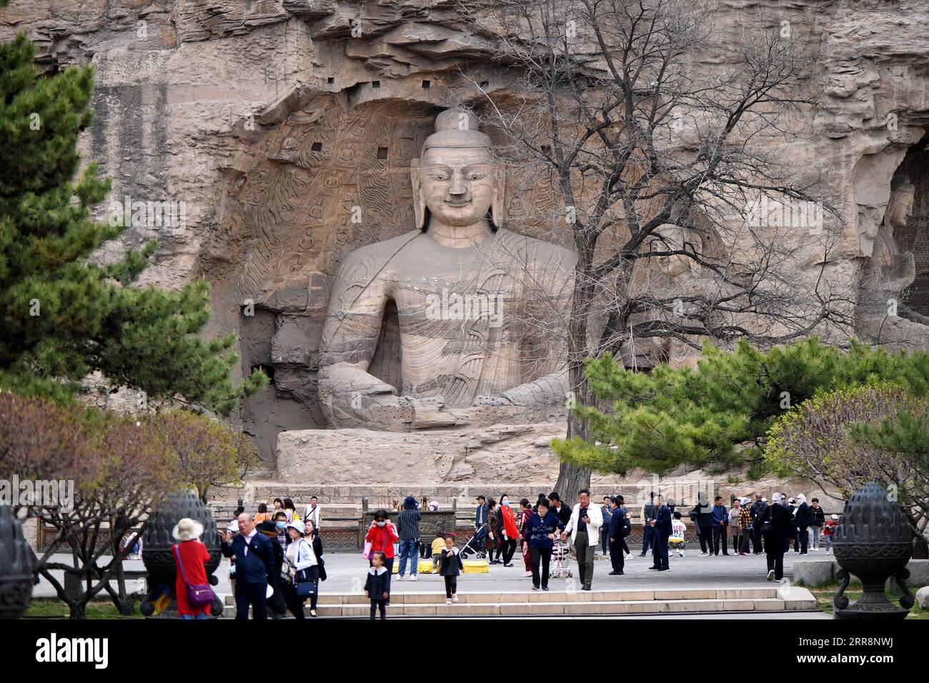210514 -- TAIYUAN, May 14, 2021 -- Tourists visit the Yungang Grottoes in Datong, north China s Shanxi Province, on May 9, 2021. Listed as a UNESCO World Heritage site in 2001, the Yungang Grottoes is a 1,500-year-old Buddhist site that contains more than 51,000 statues of the Buddha, with the largest measuring 17 meters high and the smallest two centimeters. The Yungang Grottoes Research Institute, for its part, boasts a relics protection and restoration team mainly composed of professionals in their 20s and 30s, who are trying their very best to keep these statues in their prime condition as Stock Photo