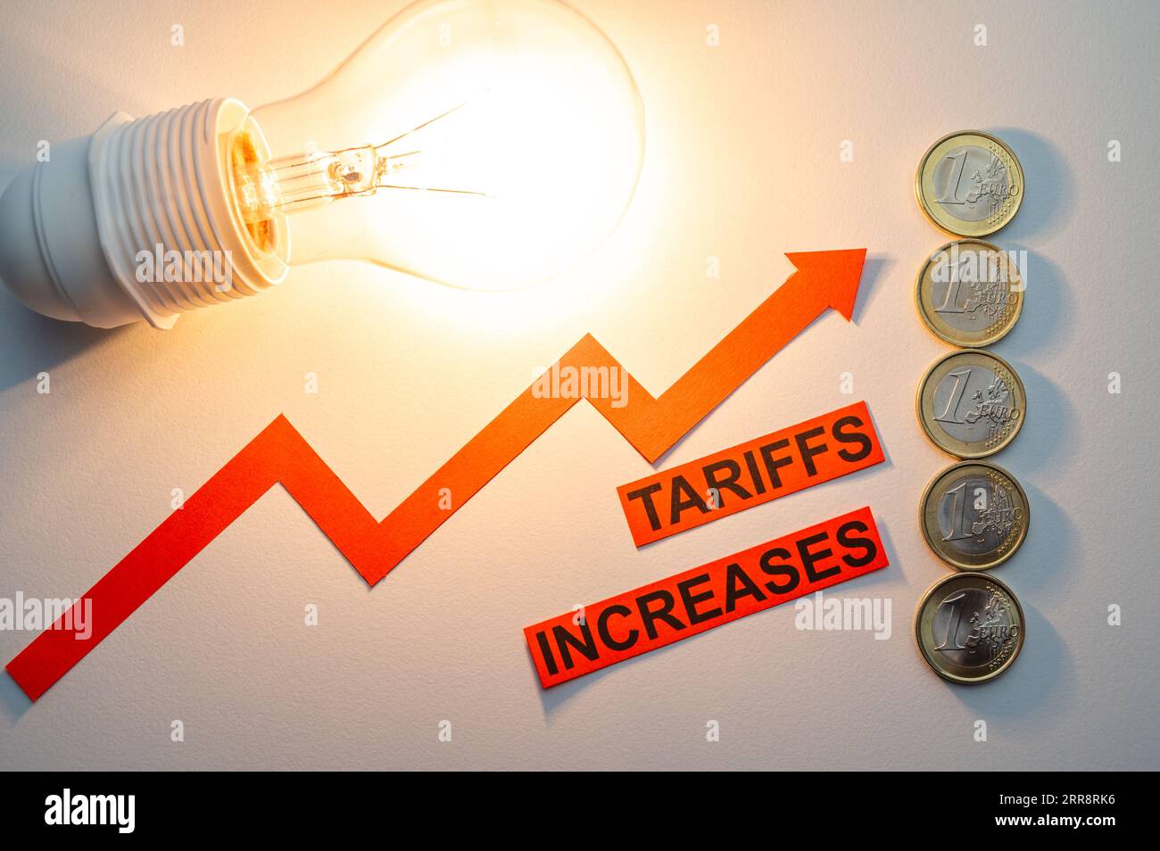 Illuminated light bulb, next to coins and ascending line, and text Tariffs increases. Increased