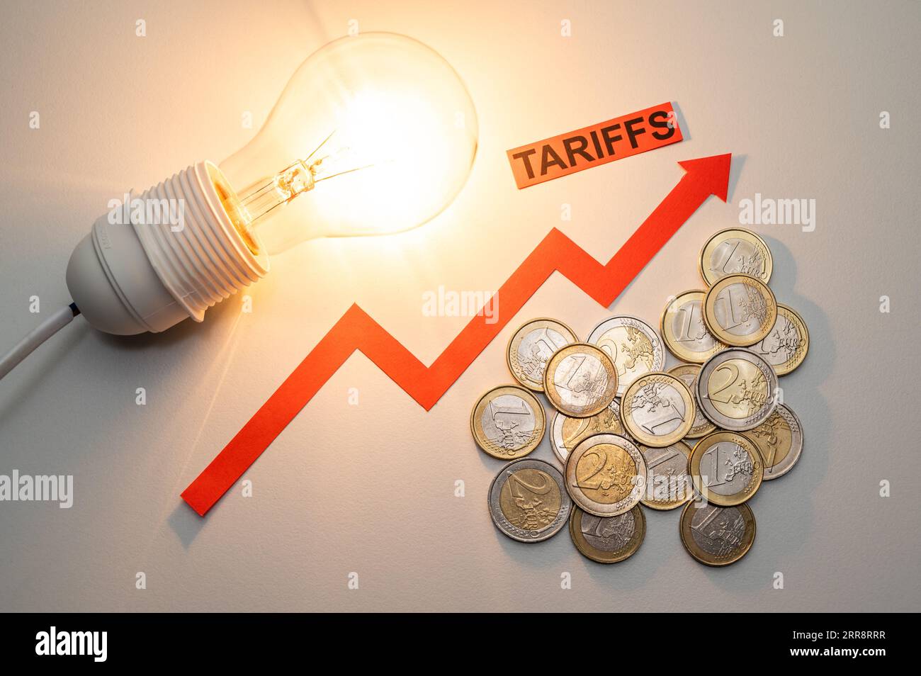 Illuminated light bulb, next to coins and ascending line, and text Tariffs increases. Increased