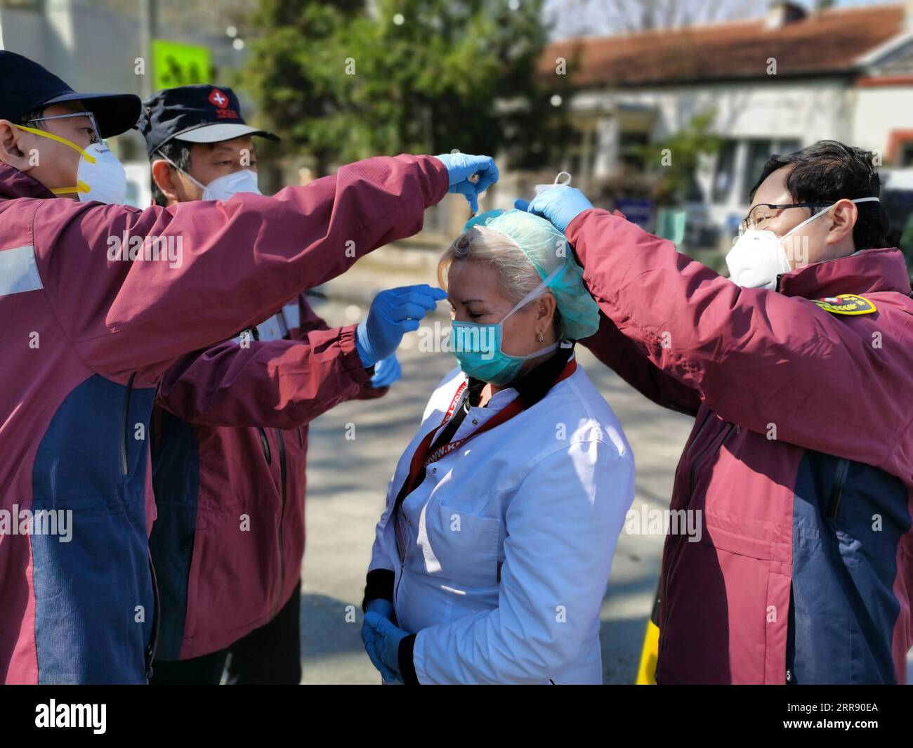 210521 -- BEIJING, May 21, 2021  -- Chinese expert medical team members help a local doctor changing her mask in Belgrade, Serbia, on April 4, 2020. TO GO WITH HEADLINES OF MAY 21, 2021  CHINA-XI JINPING-GLOBAL HEALTH SUMMIT-CLOSING IMMUNIZATION GAPCN xinhua PUBLICATIONxNOTxINxCHN Stock Photo