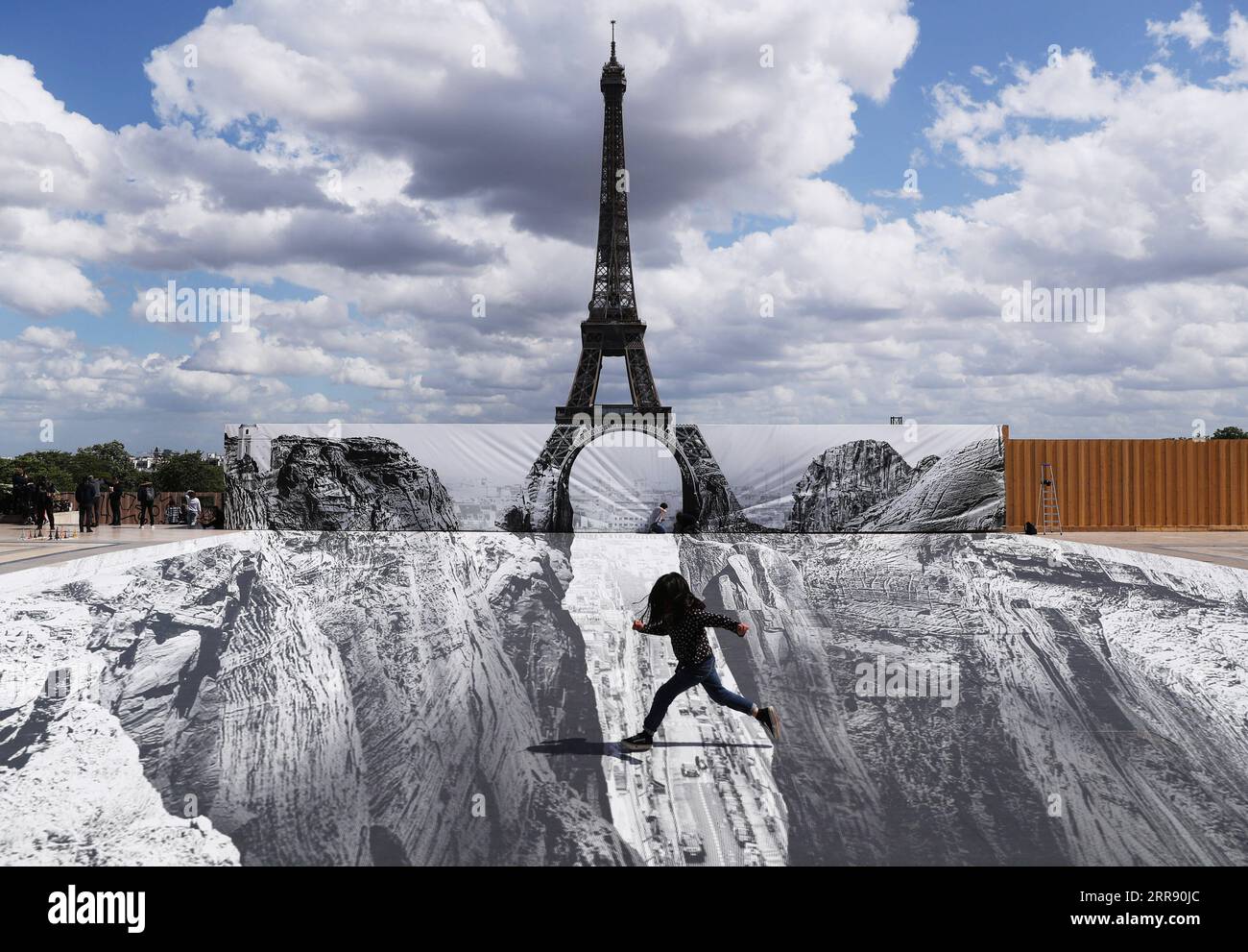 Bilder des Jahres 2021, News 05 Mai News Themen der Woche KW20 News Bilder des Tages 210521 -- PARIS, May 21, 2021 -- A girl poses for photos on the Trocadero square near the Eiffel Tower where French artist and photographer known as JR set his artwork, in Paris, France, on May 21, 2021.  FRANCE-PARIS-EIFFEL TOWER-STREET ART GaoxJing PUBLICATIONxNOTxINxCHN Stock Photo