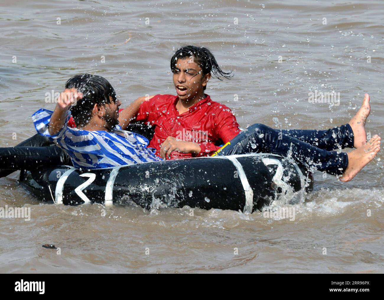 210530-lahore-pakistan-may-30-2021-people-cool-themselves-in-a