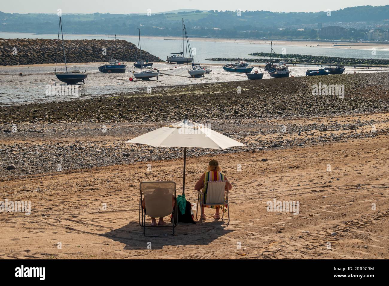 Sunbathers at Colwyn bay harbour in North Wales. Stock Photo