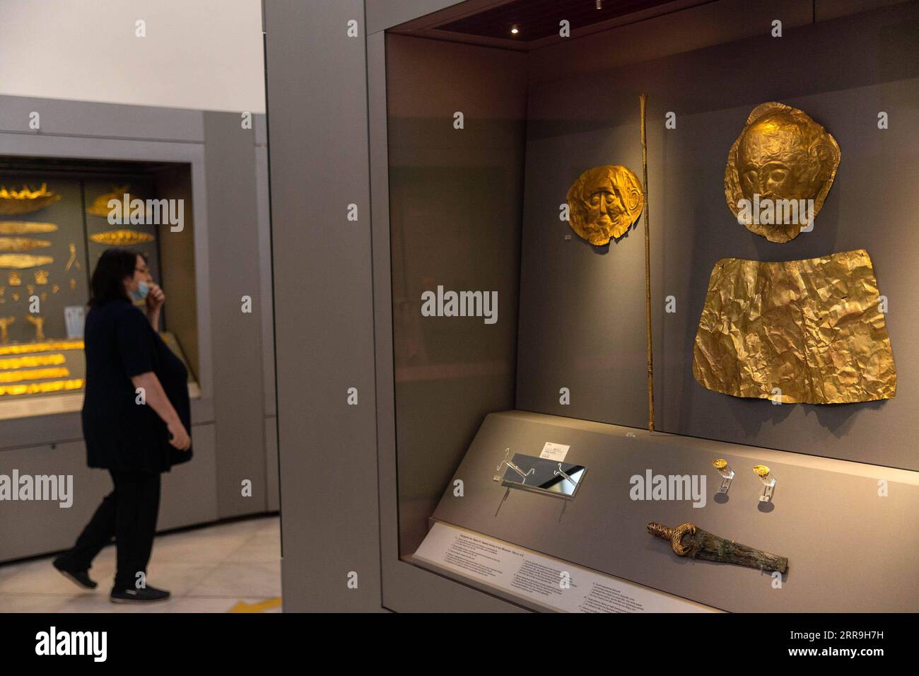 210617 -- ATHENS, June 17, 2021 -- A visiter views exhibits at the National Archaeological Museum in Athens, Greece, June 7, 2021. The imposing golden mask of Agamemnon welcomes visitors at the National Archaeological Museum here, standing out among other finds from the royal cemetery of the ancient city of Mycenae on the Peloponnese peninsula dating back to the 16th century BC. TO GO WITH Interview: Ancient Greek golden death-masks of Mycenae still engulfed in mystery, says archaeologist  GREECE-ATHENS-GOLD MASKS-NATIONAL ARCHAEOLOGICAL MUSEUM MariosxLolos PUBLICATIONxNOTxINxCHN Stock Photo