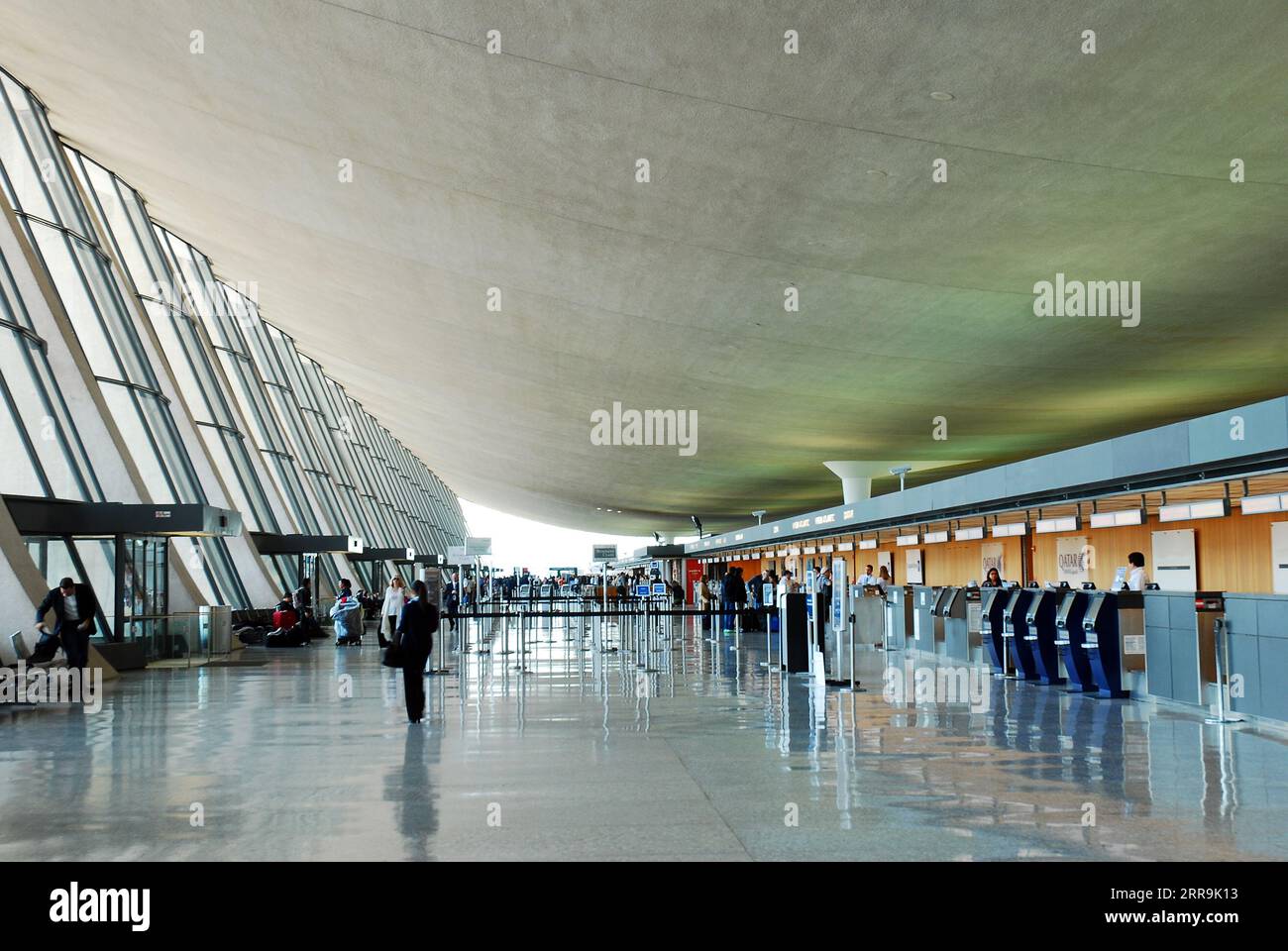 passengers and travelers walk through the Main Terminal of Dulles International Airport, designed by Eero Saarinen, near Washington, DC Stock Photo