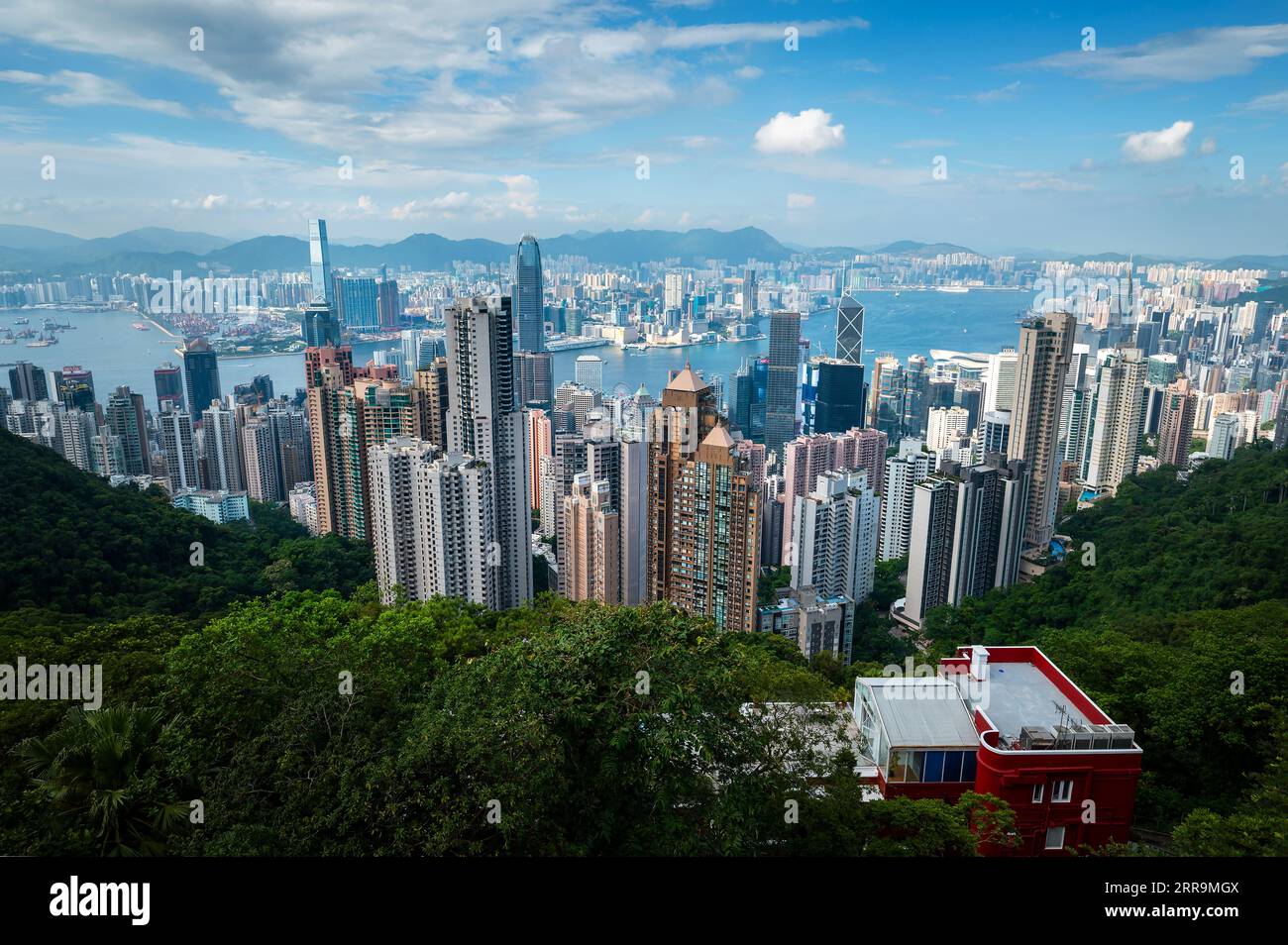 Landmark view of Hong Kong island downtown modern cityscape on a blue sky daytime seen from the Victoria peak rising high above the Special Administra Stock Photo