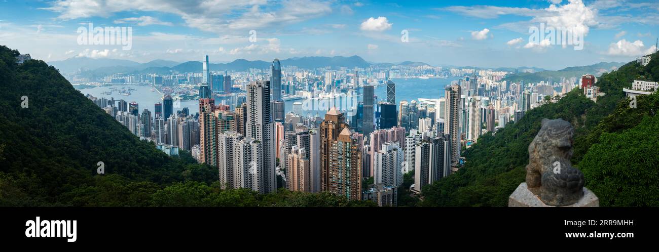 Panoramic view of Hong Kong island downtown modern cityscape on a blue sky daytime seen from the Victoria peak rising high above the Special Administr Stock Photo