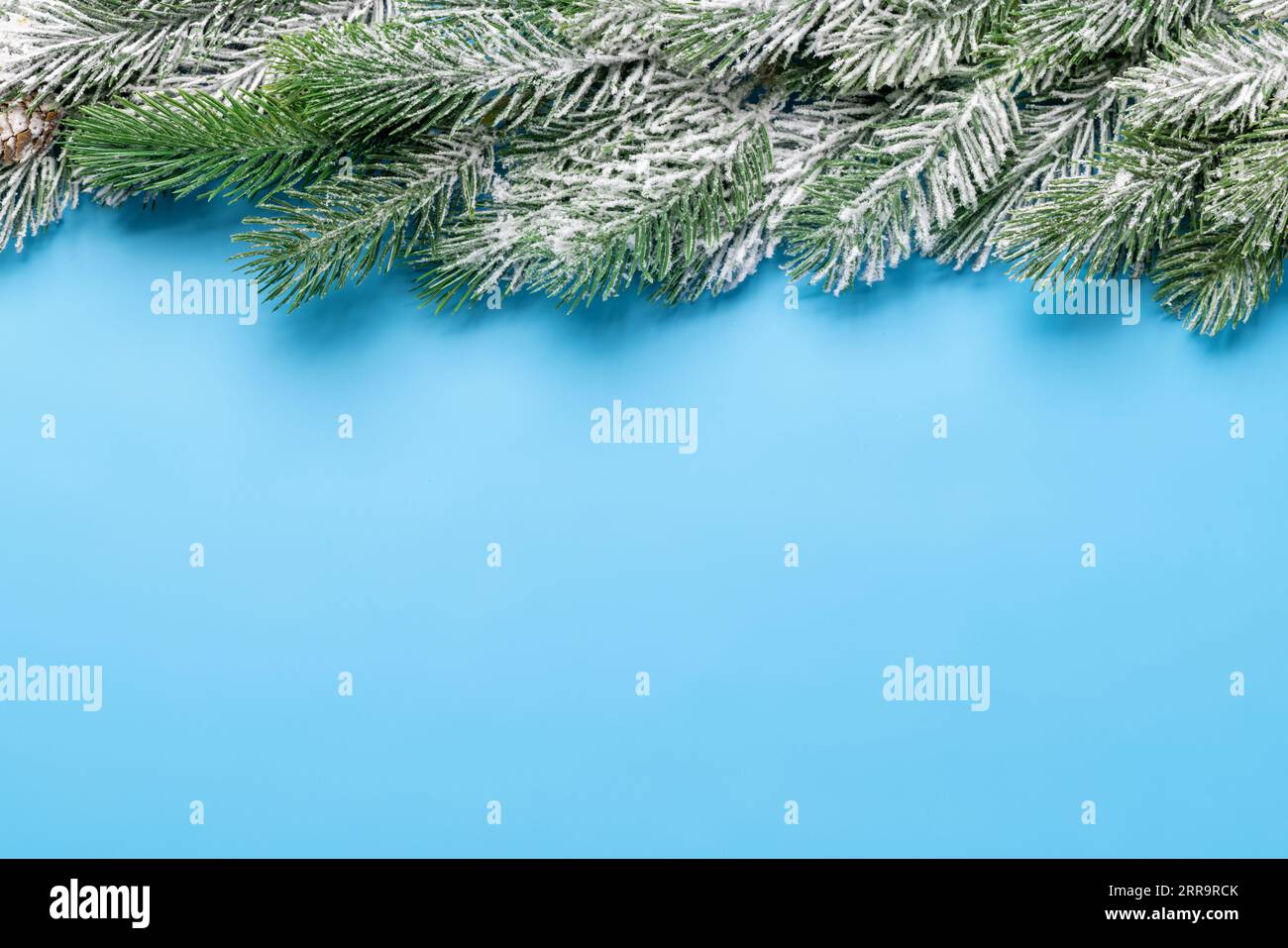 Christmas fir tree branch frame over blue background with space for ...