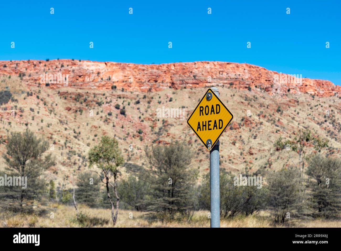 A sign to warn bicycle riders on the Simpsons Gap Bicycle Path near Alice Springs, Northern Territory, Australia, of an upcoming road with traffic Stock Photo
