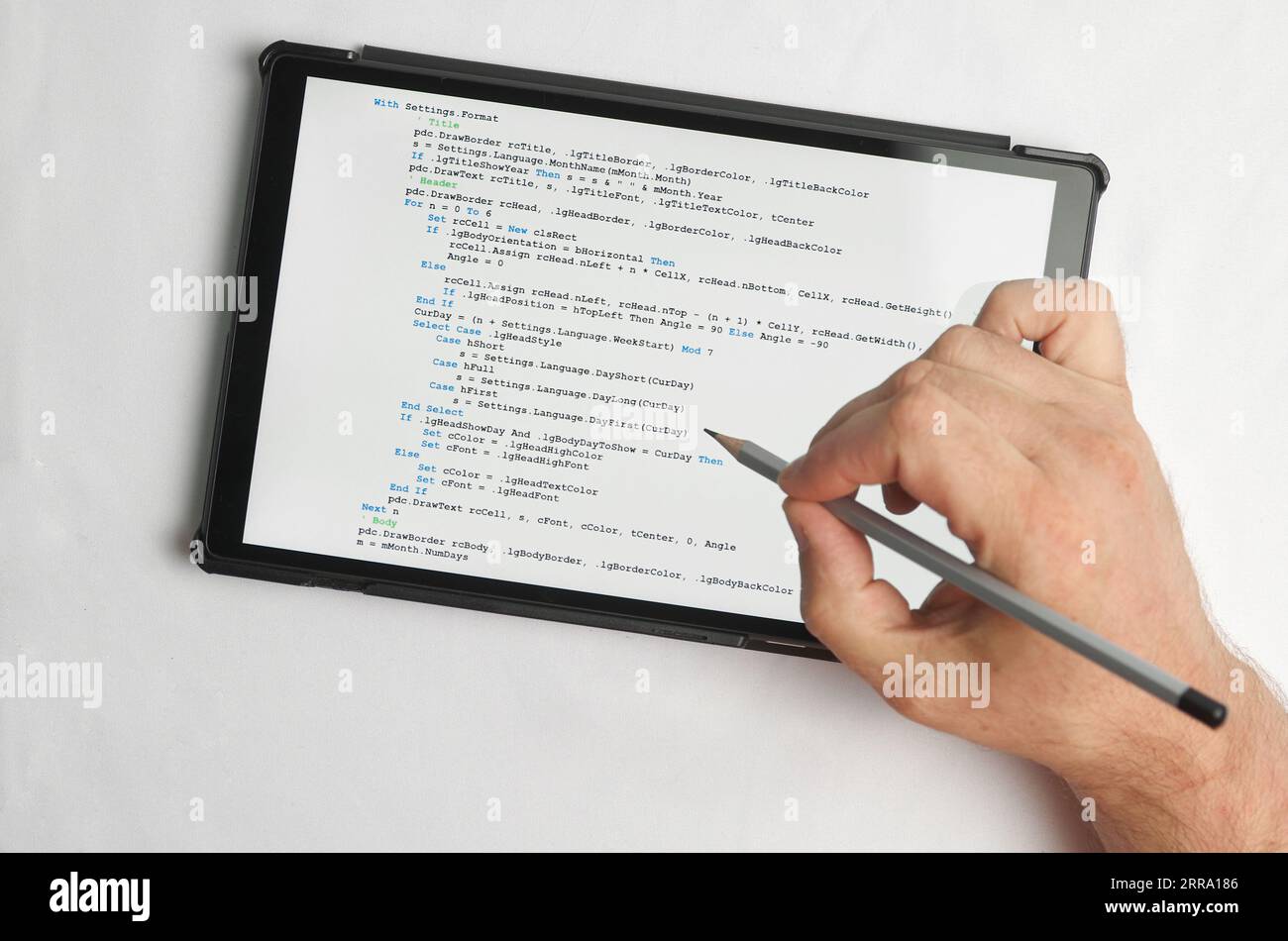 Programming and coding concept. A hand with a pencil writes a program listing on the screen Stock Photo