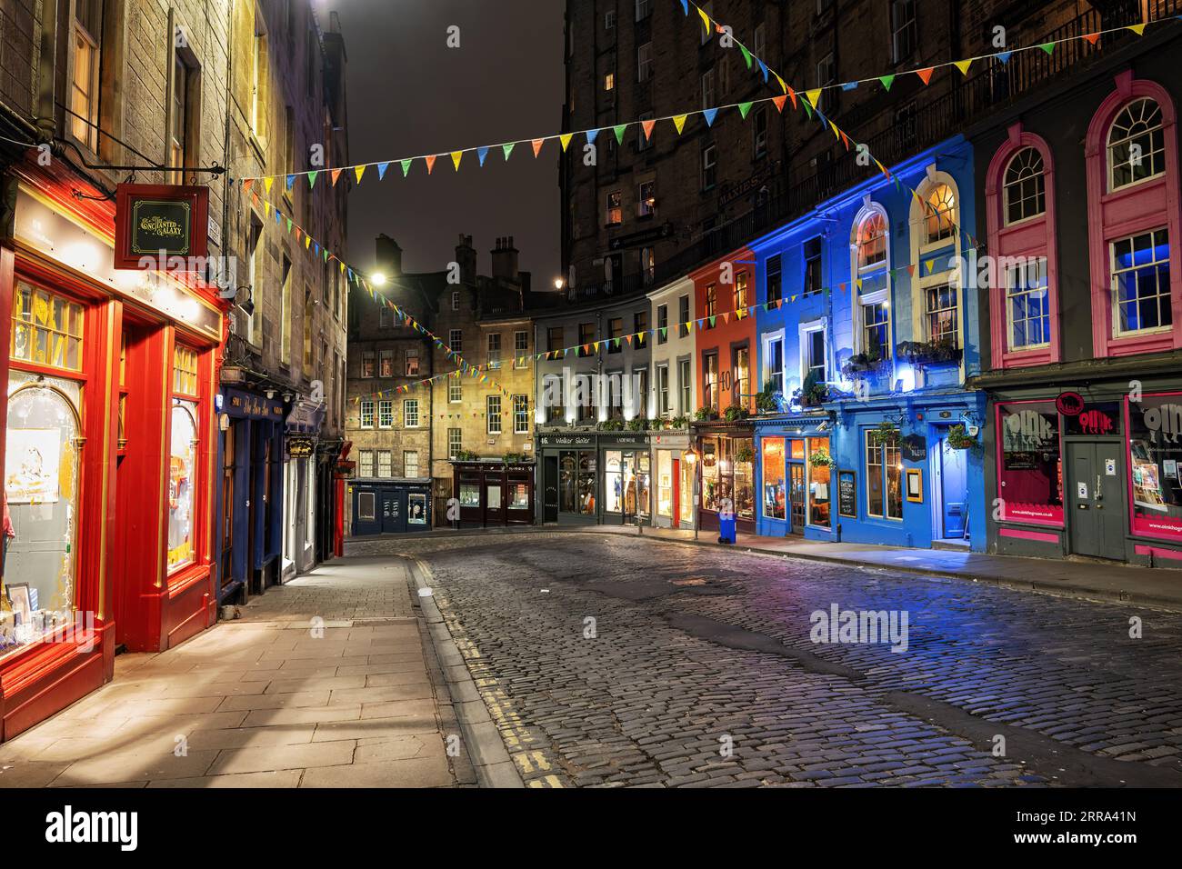 Victoria Street and West Bow by night in city of Edinburgh, Scotland. Picturesque winding road in the Old Town with colorful buildings and retail stor Stock Photo