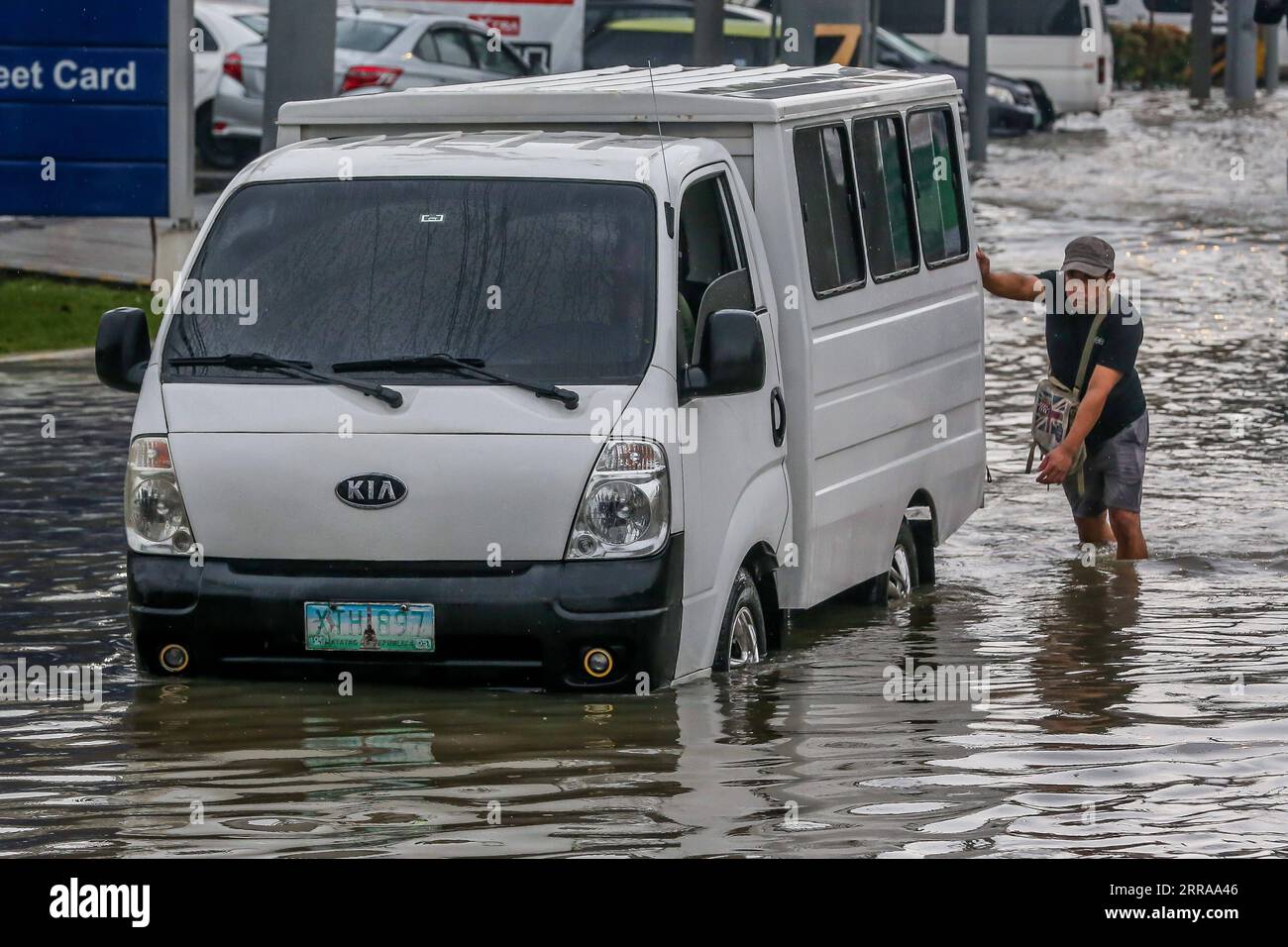 210724 -- RIZAL PROVINCE, July 24, 2021 -- A man pushes a stalled vehicle through flood water brought by heavy monsoon rains in Rizal Province, the Philippines, July 24, 2021. The Philippines have evacuated more than 15,000 people in Metro Manila and some parts of the country amid flood threat, disaster management authorities said on Saturday.  PHILIPPINES-RIZAL PROVINCE-MONSOON FLOODS RouellexUmali PUBLICATIONxNOTxINxCHN Stock Photo