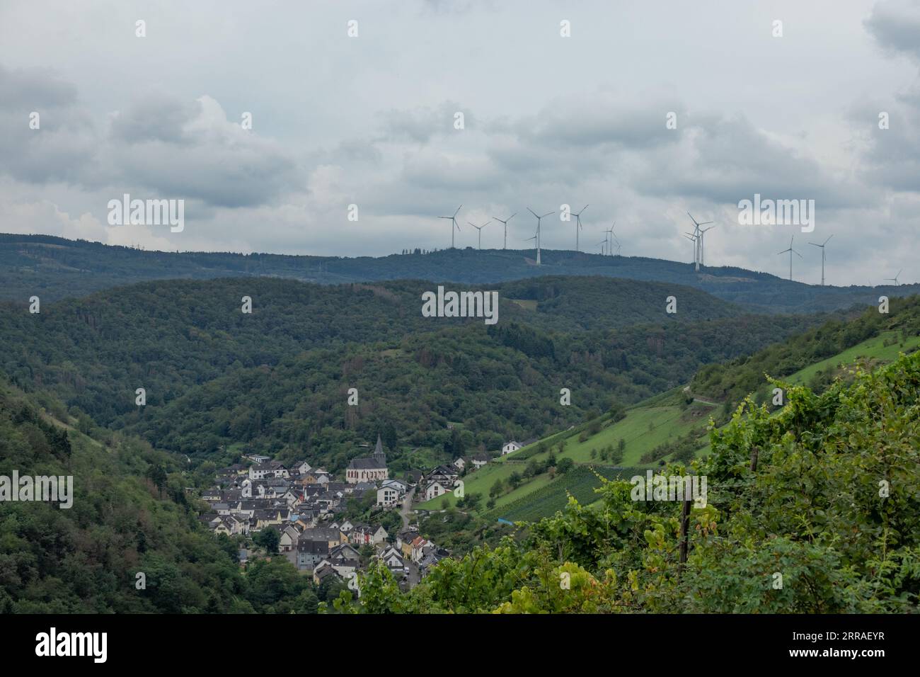 A wind farm towers over the hamlet of Steeg near Bacharach in the Rhineland, Germany Stock Photo