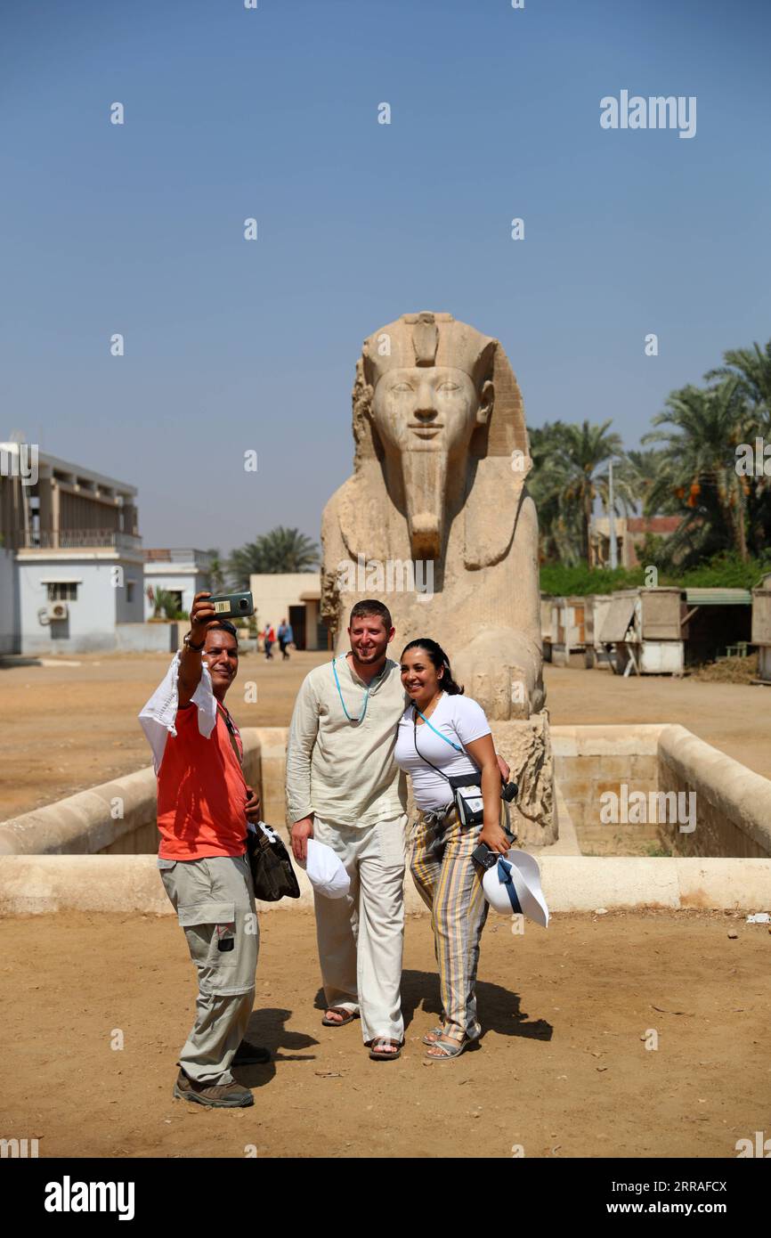 210728 -- CAIRO, July 28, 2021 -- Tourists take a selfie in front of the statue of Sphinx at the ruins of ancient Egyptian city of Memphis, around 23 kilometers southwest to Cairo, capital of Egypt, July 28, 2021. Memphis, founded around 3,100 BC, was the capital of ancient Egypt during the Old Kingdom spanning from 2700-2200 BC and remained an important city throughout ancient Egyptian history. Today, the ruins of the former capital offer fragmented evidence of its past. Together with its necropolis the pyramid fields from Giza to Dahshur, Memphis was inscribed as a World Heritage Site in 197 Stock Photo
