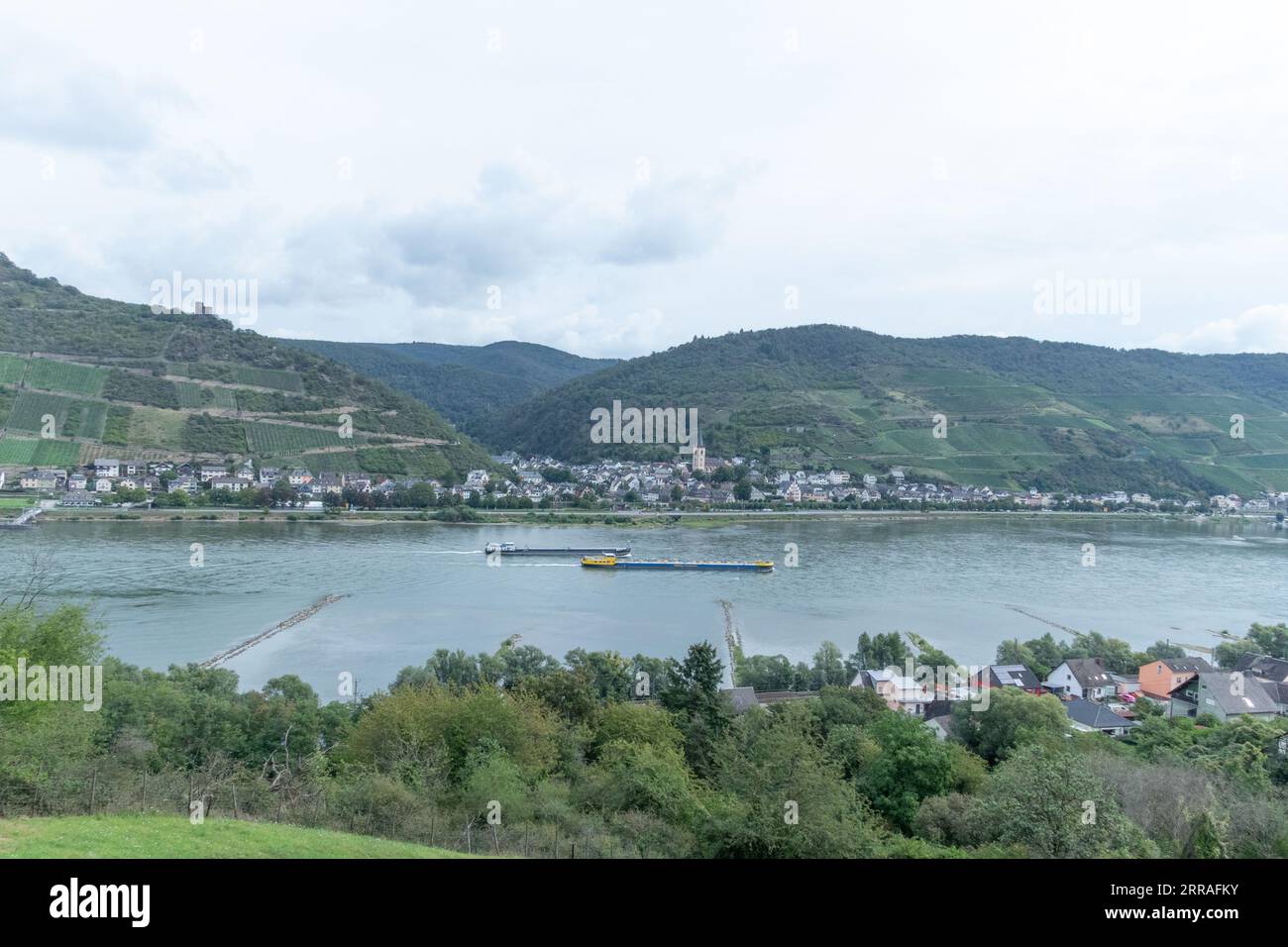 Commercial barges and other river traffic proceed along the River Rhine in the Mainz-Bingen area, Germany Stock Photo
