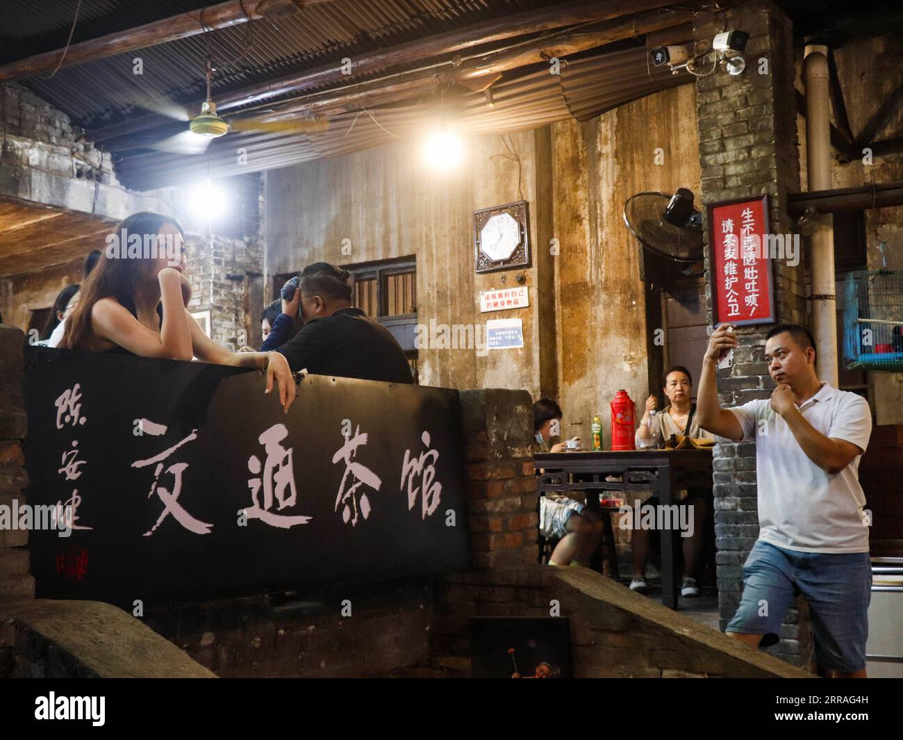 210730 -- CHONGQING, July 30, 2021 -- A woman poses for a photo while visiting the Communications Teahouse in southwest China s Chongqing, July 26, 2021. Chen Anjian, 62, an oil painting teacher at the Sichuan Fine Arts Institute, has frequented the Chongqing Communications Teahouse for more than 20 years. Founded in 1987, the Communications Teahouse is now the only old teahouse in Chongqing that has kept the original style of the 1970s and 80s. It is one of the key cultural landmarks of Chongqing, and visited by thousands of tea lovers every day. The Communications Teahouse is the living spac Stock Photo