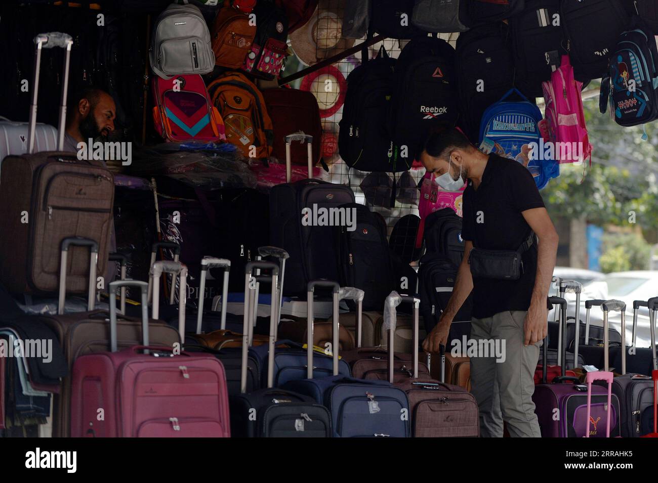 210802 -- RAWALPINDI, Aug. 2, 2021 -- A man wearing a face mask picks a suitcase at a market in Rawalpindi of Pakistan s Punjab Province on Aug. 2, 2021. Pakistan on Sunday reported 4,858 new COVID-19 cases, the National Command and Operation Center NCOC said on Monday. The NCOC said that the country s number of overall confirmed cases had risen to 1,039,695, including 943,020 recoveries.  PAKISTAN-RAWALPINDI-COVID-19-CASES AhmadxKamal PUBLICATIONxNOTxINxCHN Stock Photo