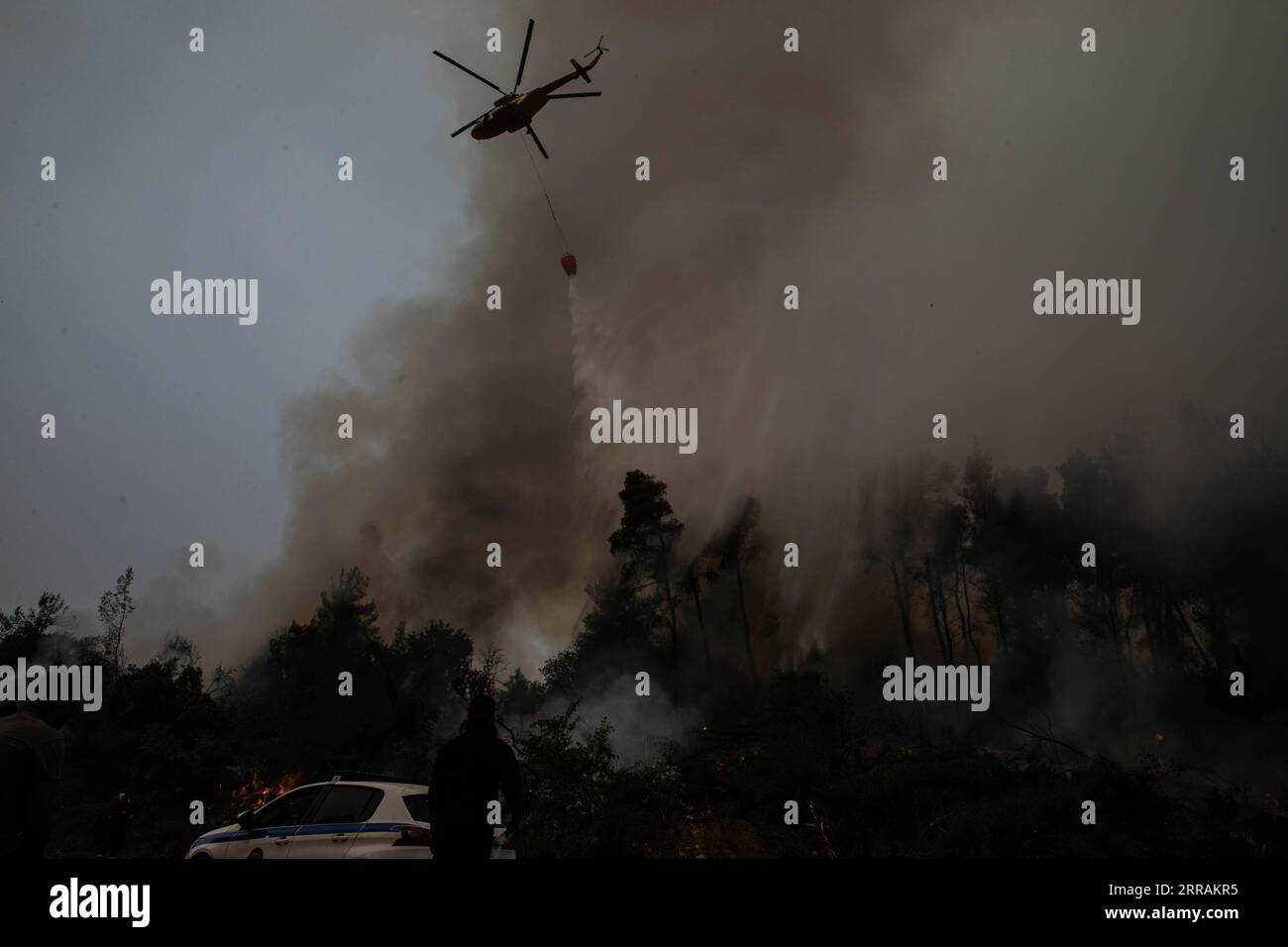 210806 -- EVIA, Aug. 6, 2021 -- A helicopter tries to extinguish a wildfire in the north of Evia island, Greece, on Aug. 5, 2021. Greek Prime Minister Kyriakos Mitsotakis said on Thursday evening that Greece is facing an extremely critical situation with multiple forest fires at the same time, while saving human lives is the government s top priority. Wildfires in the north of Athens leapt back to life on Thursday as Greece also faces flare-ups on the island of Evia, in Ancient Olympia in the northwestern Peloponnese and in other parts of the country. TO GO WITH Greek PM says saving human live Stock Photo