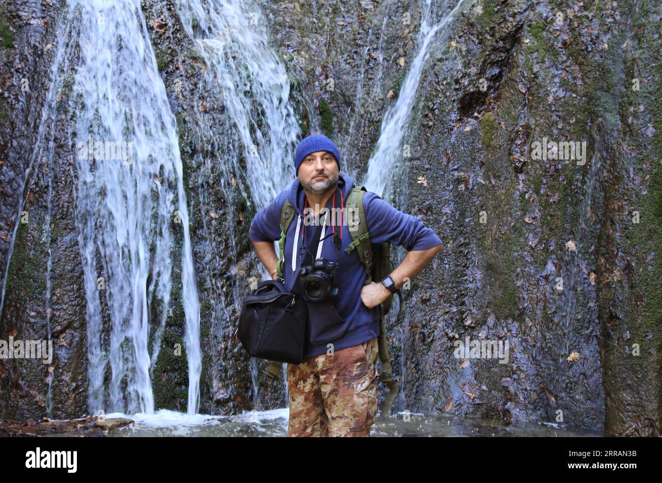 photographer standing near waterfall Stock Photo