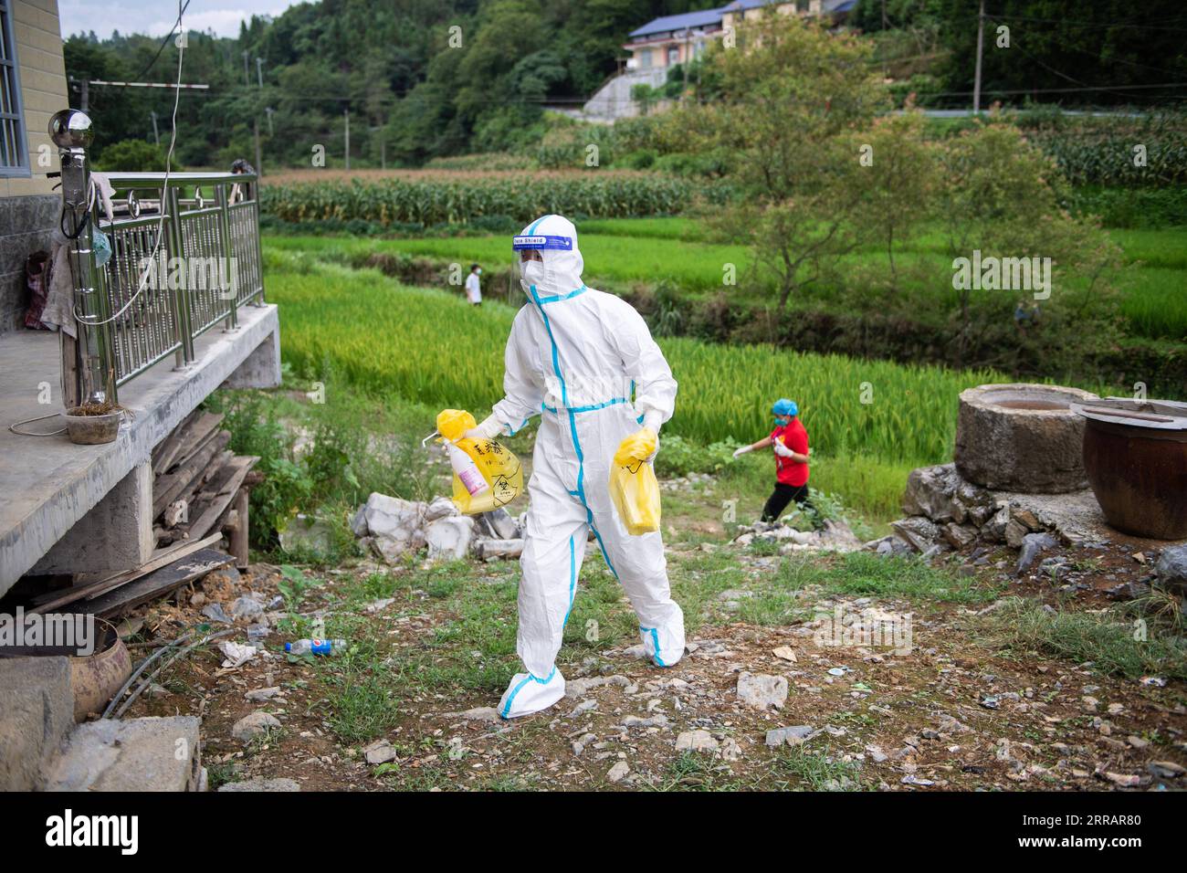 210814 -- ZHANGJIAJIE, Aug. 14, 2021 -- Luo Jinwu walks to offer door-to-door nucleic acid sampling services in Yangping Village of Yongding District in Zhangjiajie City, central China s Hunan Province, Aug. 12, 2021. Luo Jinwu and his wife Xiang Ka are medical workers from Zhangjiajie Hospital of Traditional Chinese Medicine. Since the recent resurgence of COVID-19 in Zhangjiajie from July 29, Luo has been conducting nucleic acid tests especially in the countryside, while Xiang has stationed in the hospital to attend to patients. Being apart for about half a month, the couple kept in contact Stock Photo