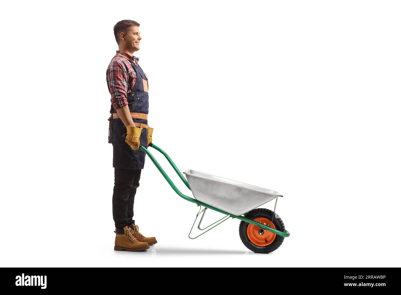 Full length profile shot of a farmer standing with an empty wheelbarrow solated on white background Stock Photo