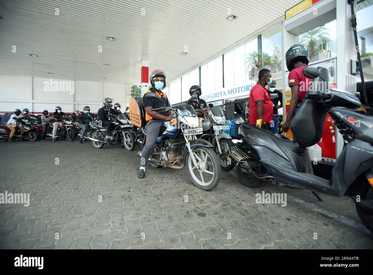 210820 -- COLOMBO, Aug. 20, 2021 -- People line up to refuel at a gas station after Sri Lankan authority announced a 10-day nationwide quarantine curfew, in Colombo, Sri Lanka, on Aug. 20, 2021. A 10-day nationwide quarantine curfew will be imposed in Sri Lanka from Friday night in order to prevent a further spread of the COVID-19 virus, the country s Army Commander and Head of the National Operations Center for Prevention of COVID-19 Outbreak, General Shavendra Silva said on Friday. Photo by /Xinhua SRI LANKA-COLOMBO-COVID-19-QUARANTINE CURFEW-PREPARATION AjithxPerera PUBLICATIONxNOTxINxCHN Stock Photo