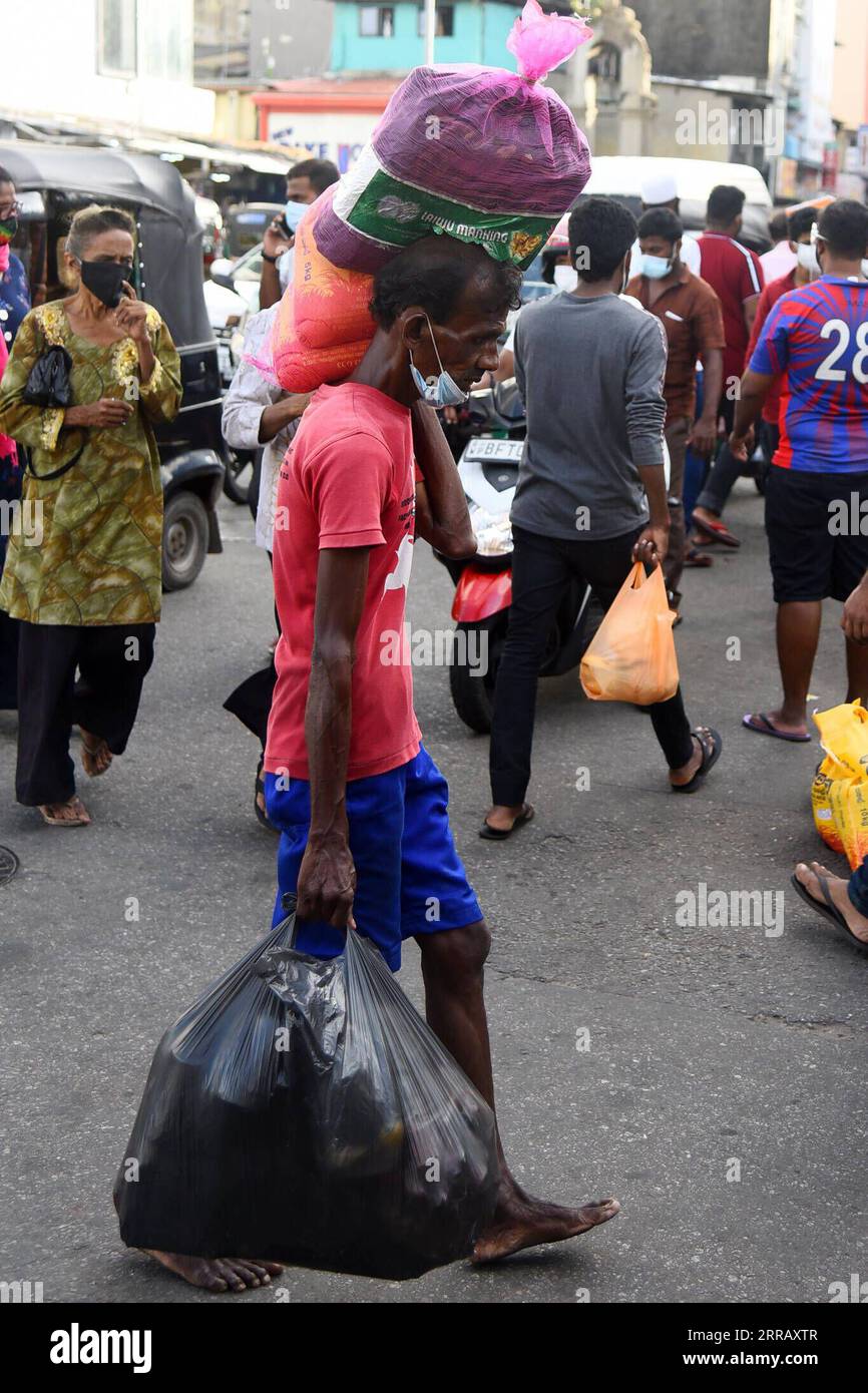 210820 -- COLOMBO, Aug. 20, 2021 -- A man carries essential goods after Sri Lankan authority announced a 10-day nationwide quarantine curfew, in Colombo, Sri Lanka, on Aug. 20, 2021. A 10-day nationwide quarantine curfew will be imposed in Sri Lanka from Friday night in order to prevent a further spread of the COVID-19 virus, the country s Army Commander and Head of the National Operations Center for Prevention of COVID-19 Outbreak, General Shavendra Silva said on Friday. Photo by /Xinhua SRI LANKA-COLOMBO-COVID-19-QUARANTINE CURFEW-PREPARATION GayanxSameera PUBLICATIONxNOTxINxCHN Stock Photo