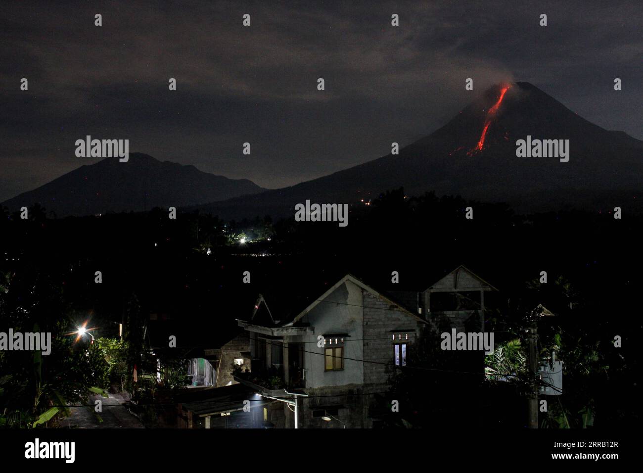 210824 -- MAGELANG, Aug. 24, 2021 -- Photo taken on Aug. 24, 2021 shows volcanic materials spewing from Mount Merapi, seen from Srumbung village in Magelang, Central Java, Indonesia. Photo by /Xinhua INDONESIA-MOUNT MERAPI-ERUPTION PriyoxUtomo PUBLICATIONxNOTxINxCHN Stock Photo