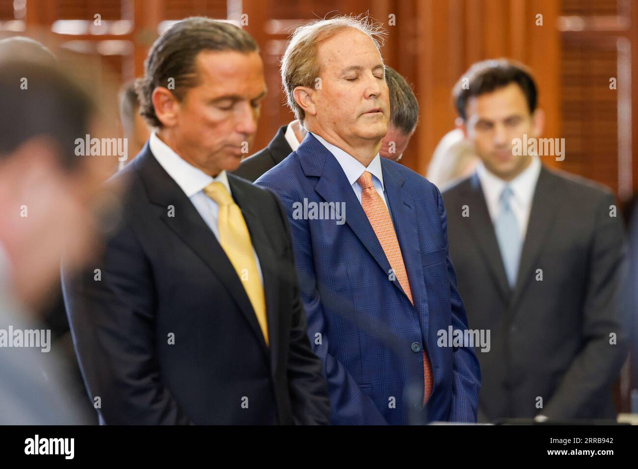 (From left) Paxton's attorney Tony Buzbee stands with Texas Attorney General Ken Paxton as Texas Sen. Phil King (not pictured) says the prayer at the beginning of the first day of Paxton’s impeachment trial in the Texas Senate chambers at the Texas State Capitol in Austin on Tuesday, Sept. 5, 2023. The Texas House, including a majority of its GOP members, voted to impeach Paxton for alleged corruption in May. (Juan Figueroa/Pool via The Dallas Morning News) Stock Photo