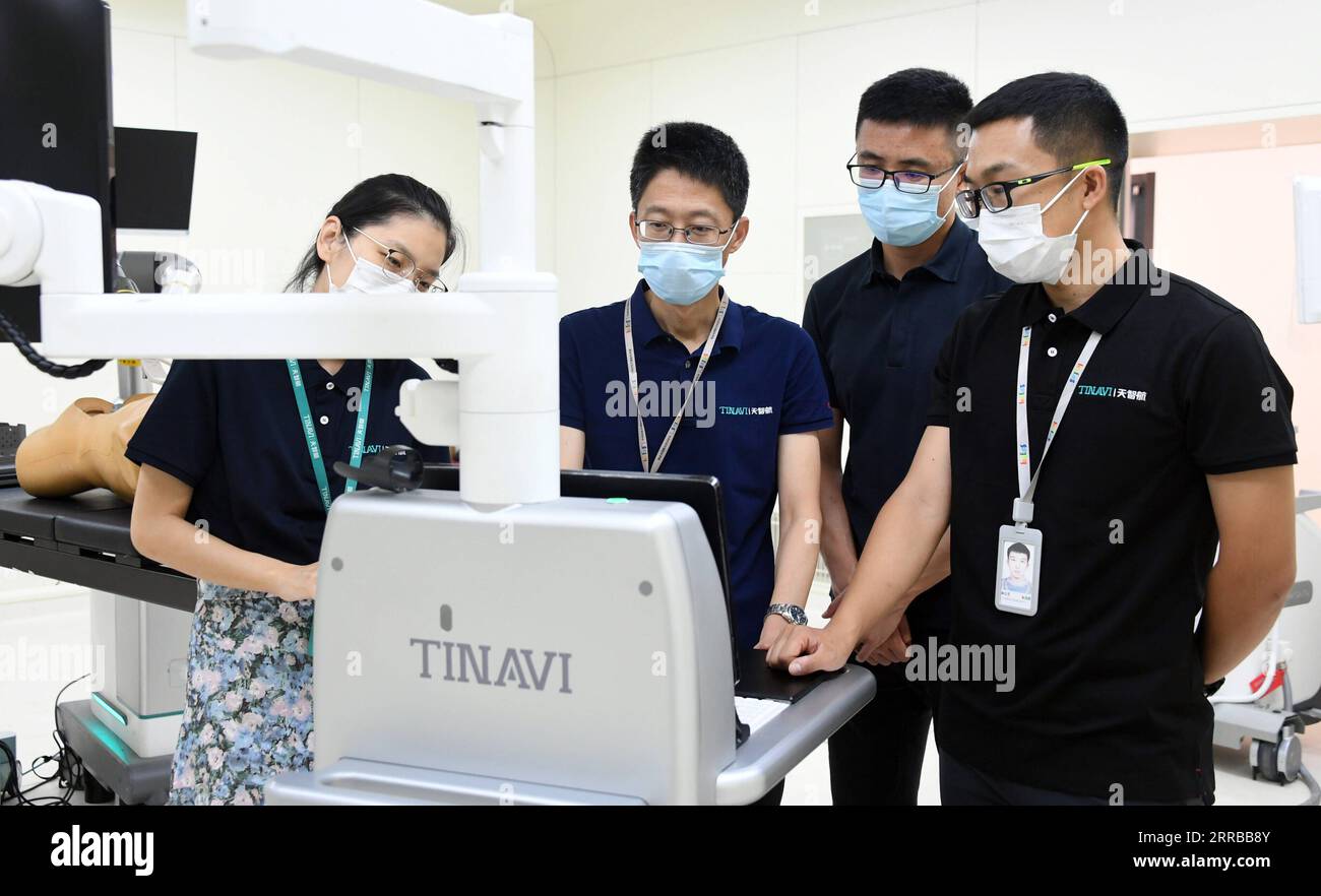 210912 -- BEIJING, Sept. 12, 2021 -- Liu Tiechang 2nd L and his colleagues of Tinavi, a Chinese tech company that specializes in the development of orthopedic surgical robots, work in a lab in Beijing, capital of China, Aug. 4, 2021. The orthopedic surgical robot could dynamically analyze the patient s anatomy as well as the spine-hip relation and carry out the individualized surgery planning exactly as planned. Beijing Haidian Hospital officially introduced orthopedic surgery robots from May 2020, and has completed more than 400 robotic surgeries by the end of August 2021.  CHINA-BEIJING-ORTH Stock Photo