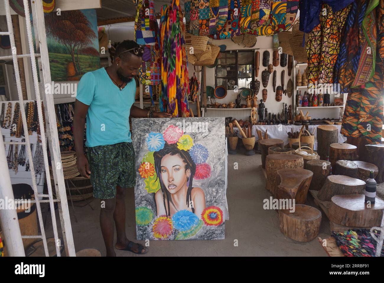 210918 -- LUSAKA, Sept. 18, 2021 -- Kelvin Mwanza, Manja Arts center founder, stands with his painting at Manja Arts center in Mtendere Township of Lusaka, Zambia, on Sept. 13, 2021. For many young people in Mtendere Township of Lusaka, Manja Arts center serves as a recreational space as well as a springboard for art-based businesses. Photo by /Xinhua TO GO WITH Feature: Zambian artist nurturing youths in businesses ZAMBIA-LUSAKA-ARTIST-BUSINESSES LillianxBanda PUBLICATIONxNOTxINxCHN Stock Photo